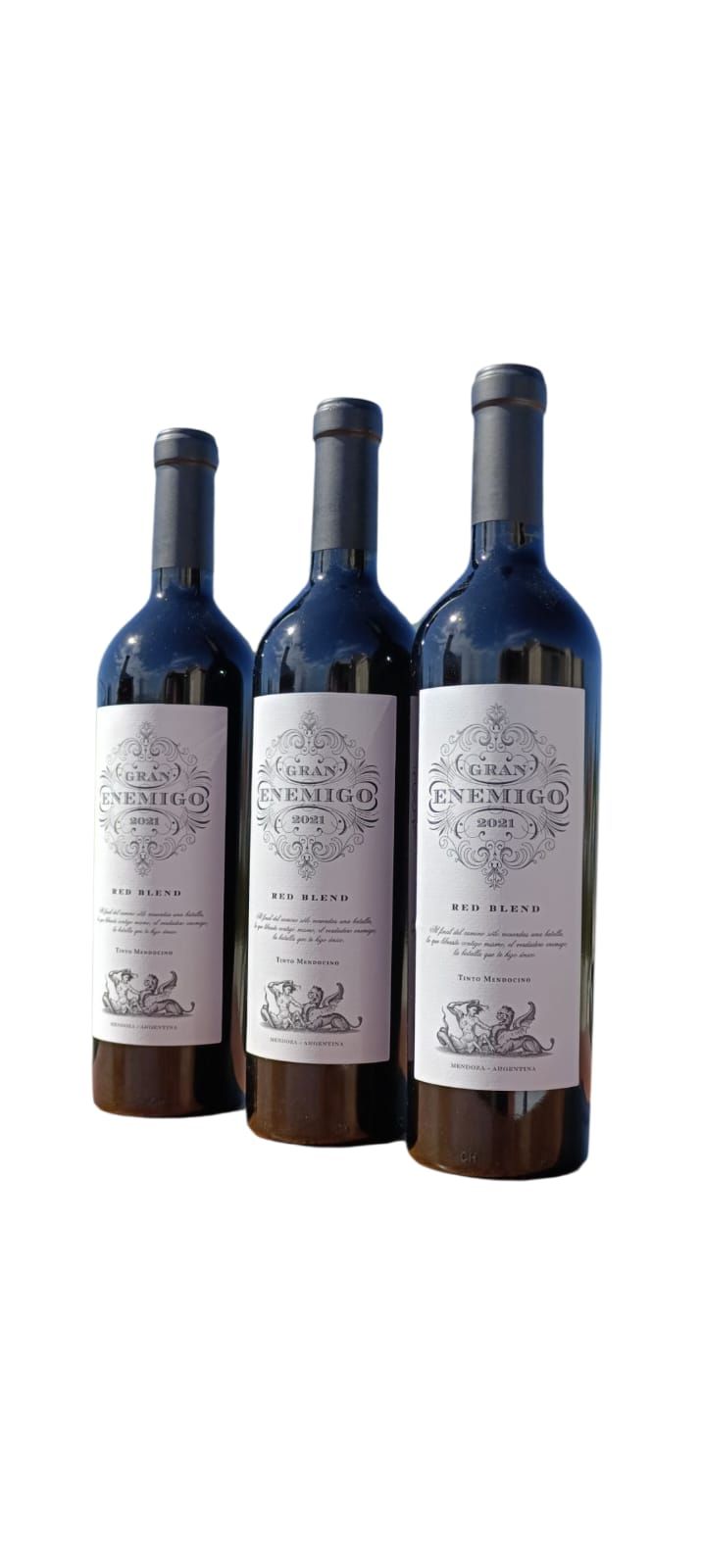 Tres botellas de vino oscuro con etiquetas blancas, agrupadas sobre un fondo blanco.
