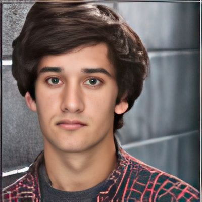 A young man in a plaid shirt looks at the camera