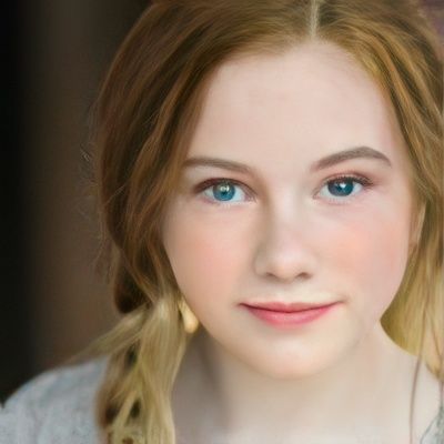 A close up of a young woman 's face with blue eyes.