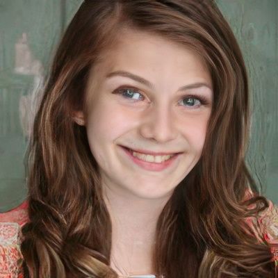 A young girl with long brown hair is smiling for the camera.