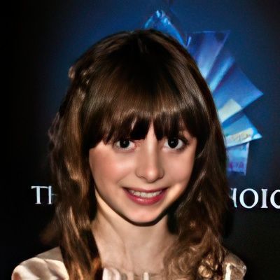 A young girl smiles in front of a sign that says the choice