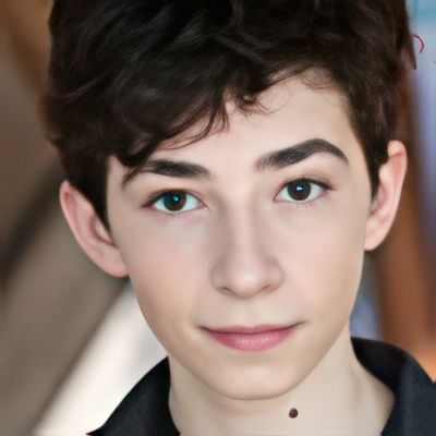 A close up of a young boy 's face with a black shirt on