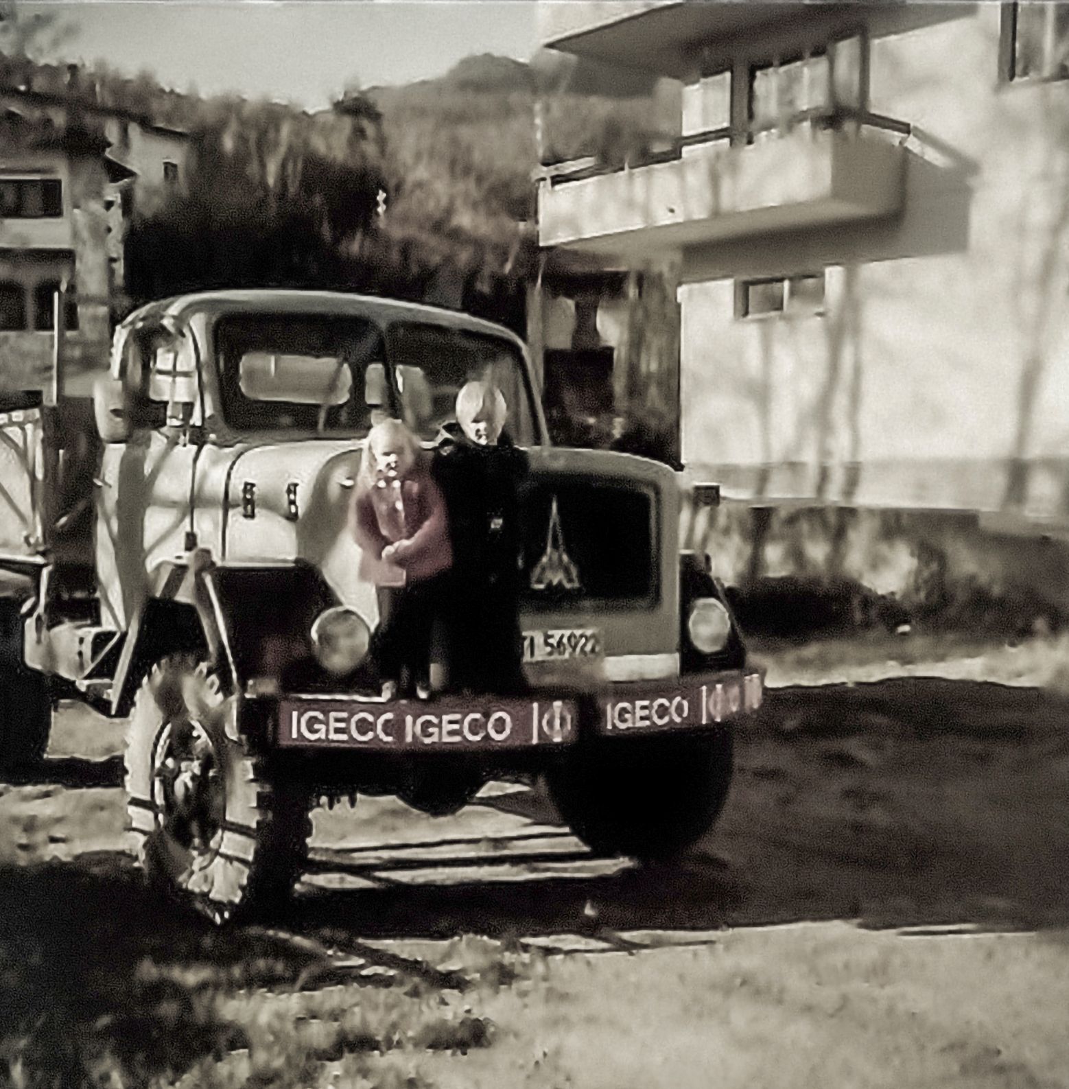 Foto d'epoca di un autocarro con 2 bambini in piedi sul paraurti