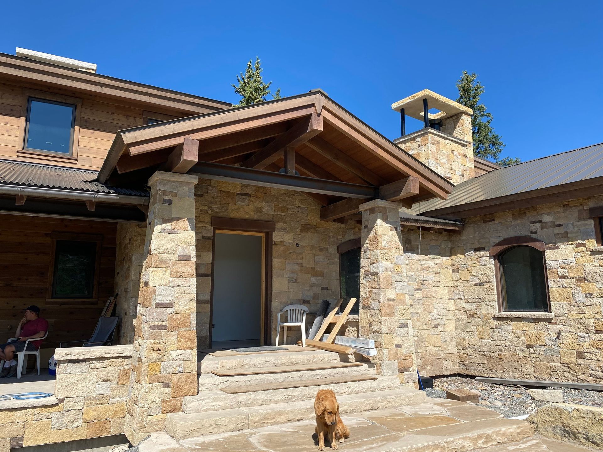 a dog is standing in front of a stone house .