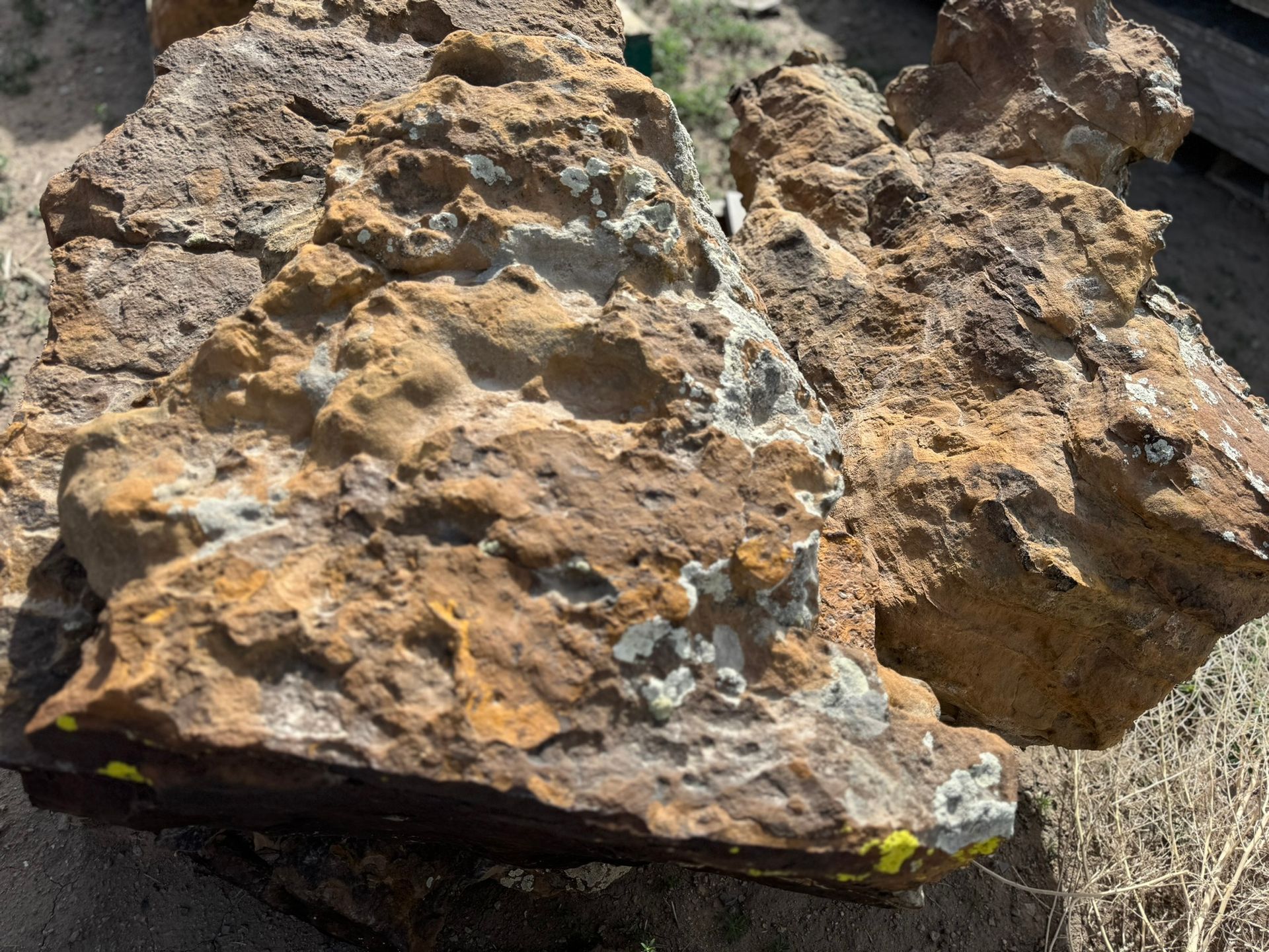 A large rock with a yellow stripe on it is sitting on the ground.