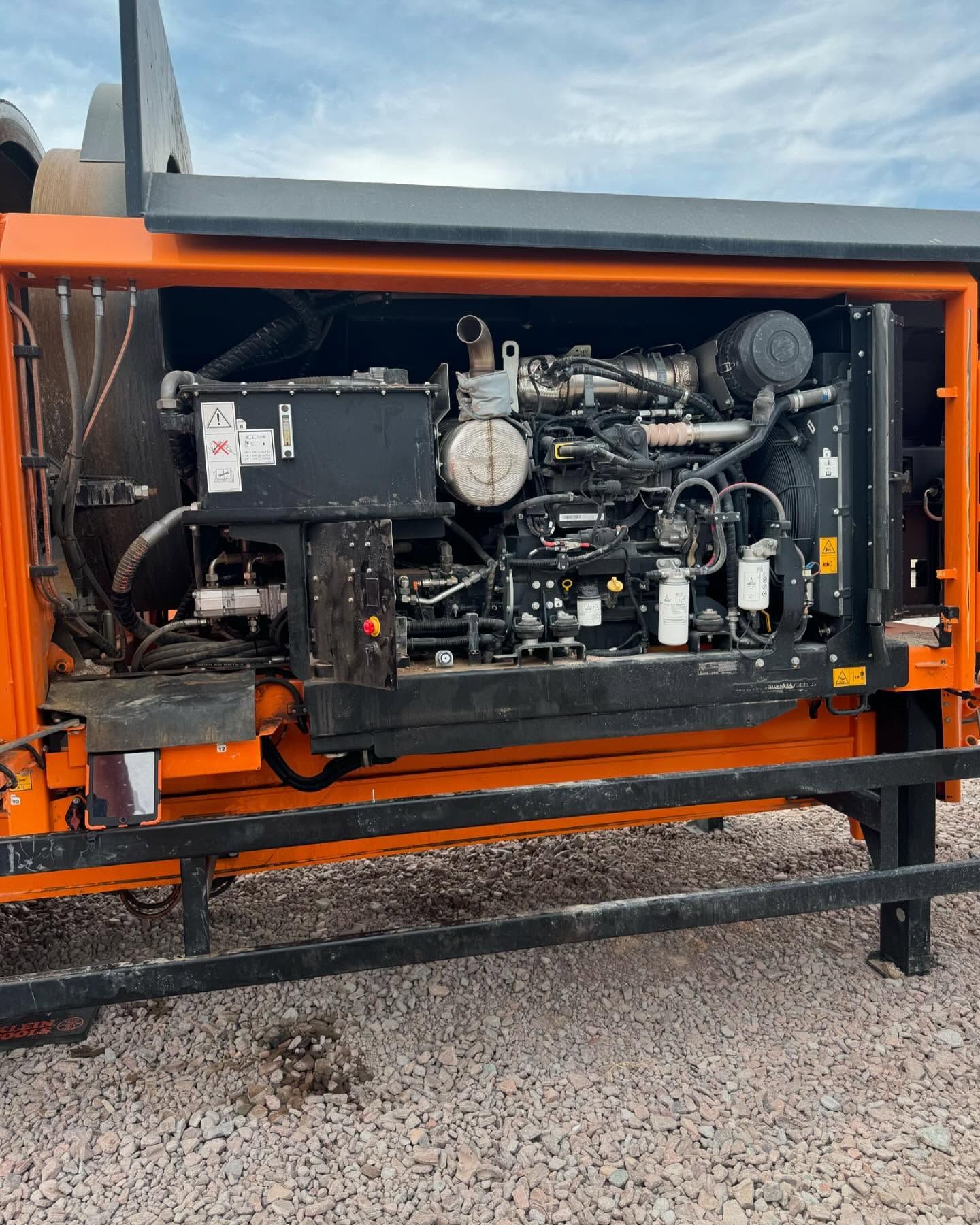 Orange generator with exposed engine components. Black frame, various tubes and wires.
