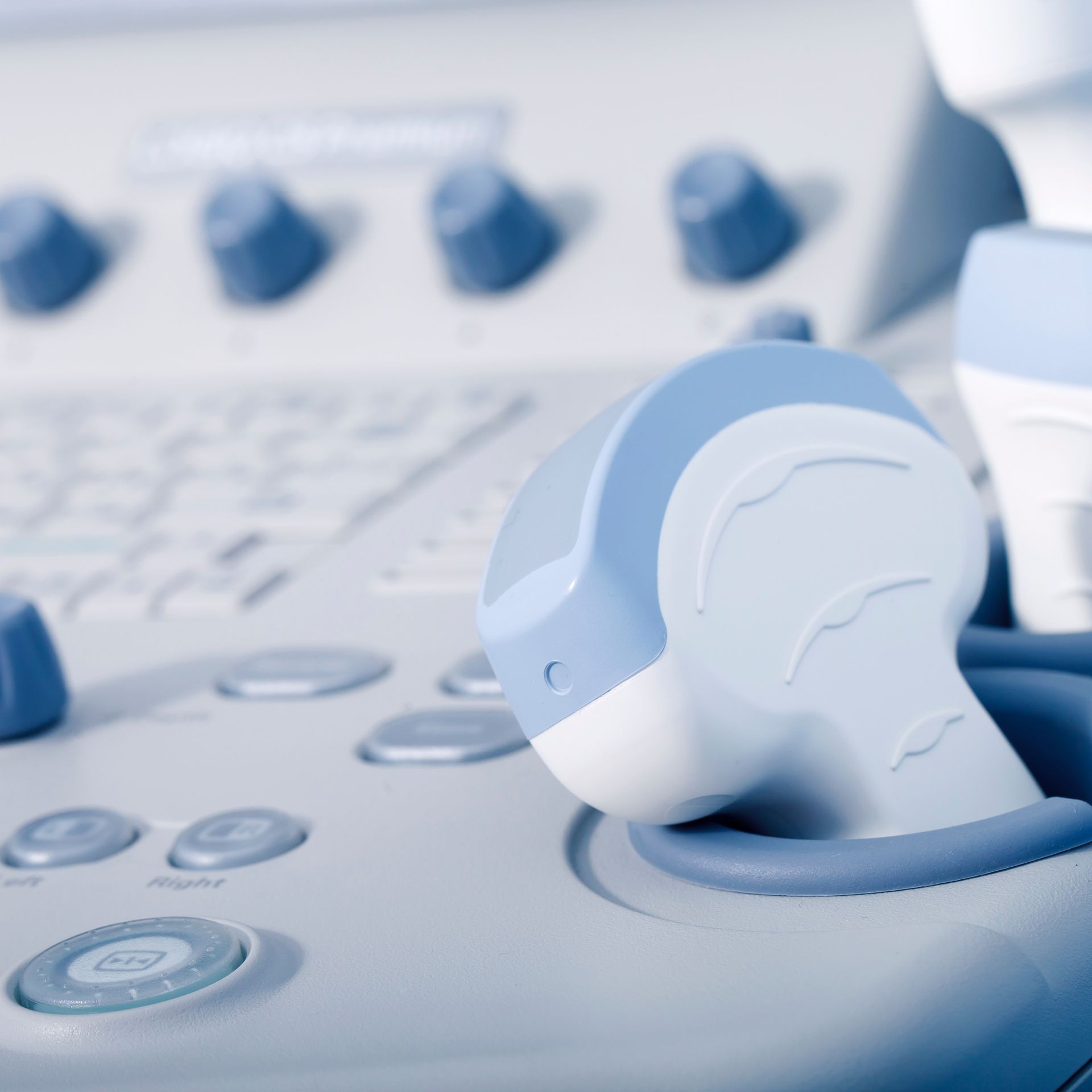 Transductor de ultrasonido azul y blanco sobre una consola médica