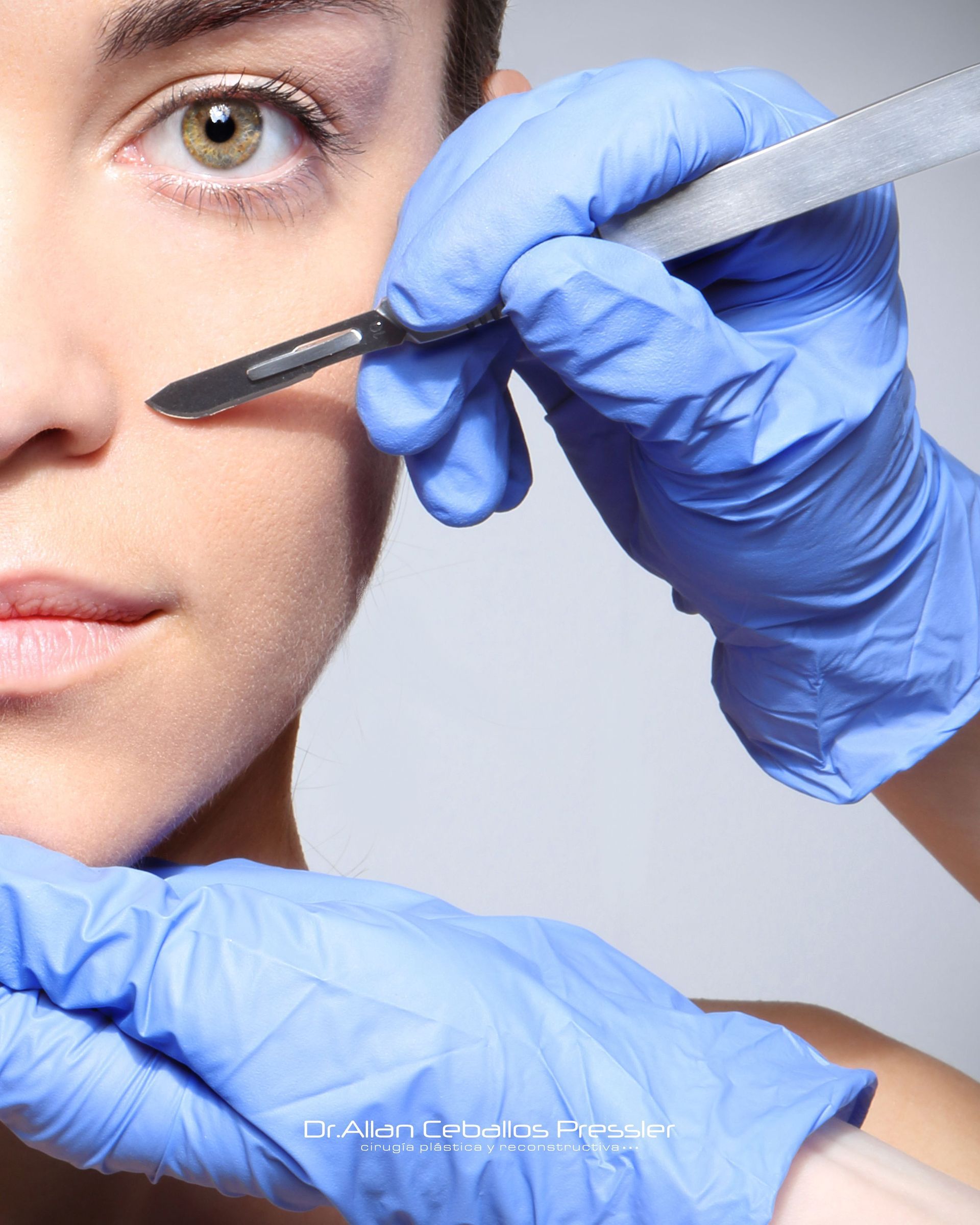 Unas manos enguantadas utilizan una brocha de maquillaje cerca del ojo de una mujer en una escena de tratamiento de belleza en primer plano.