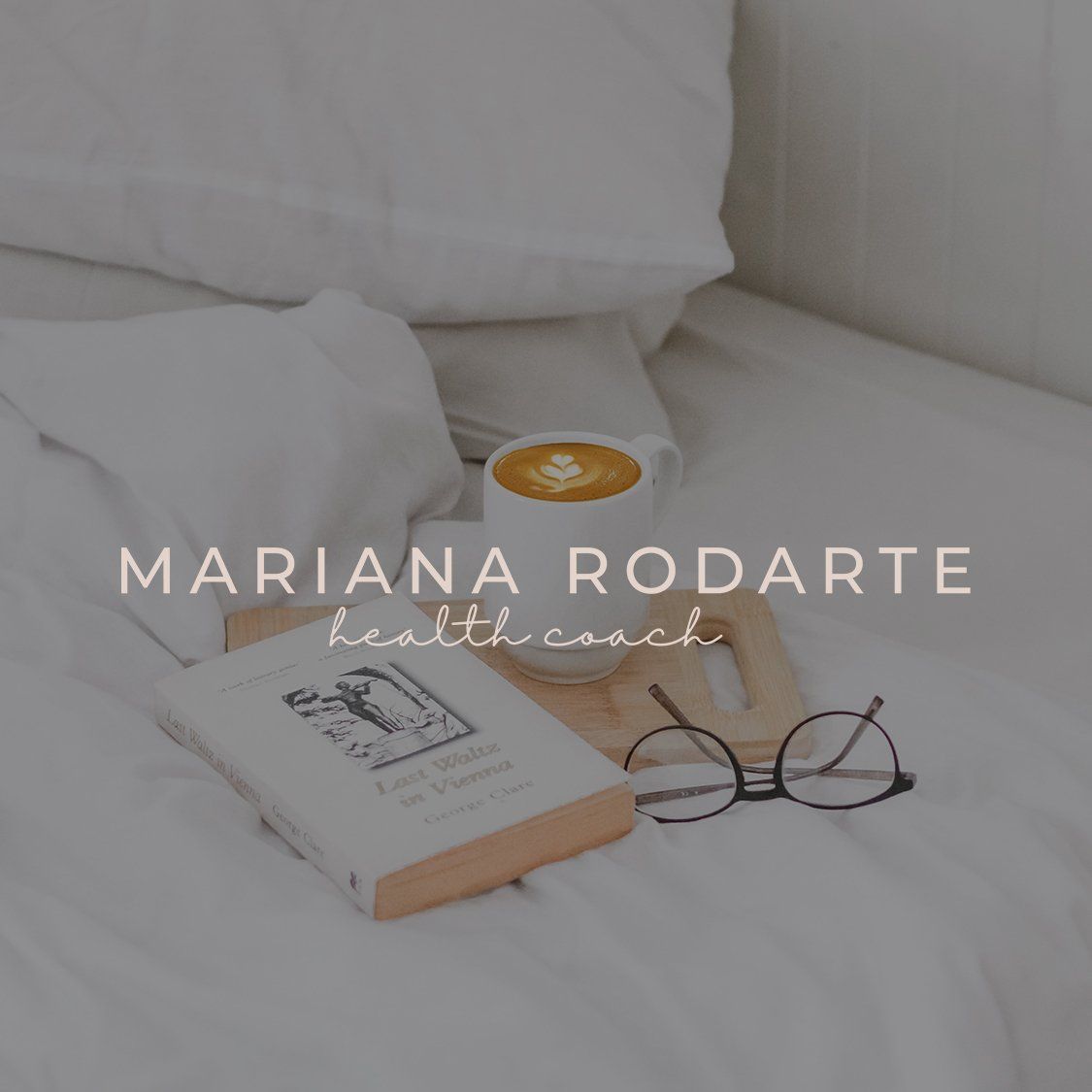 Cama acogedora con un libro, gafas y una taza de café, con el nombre 