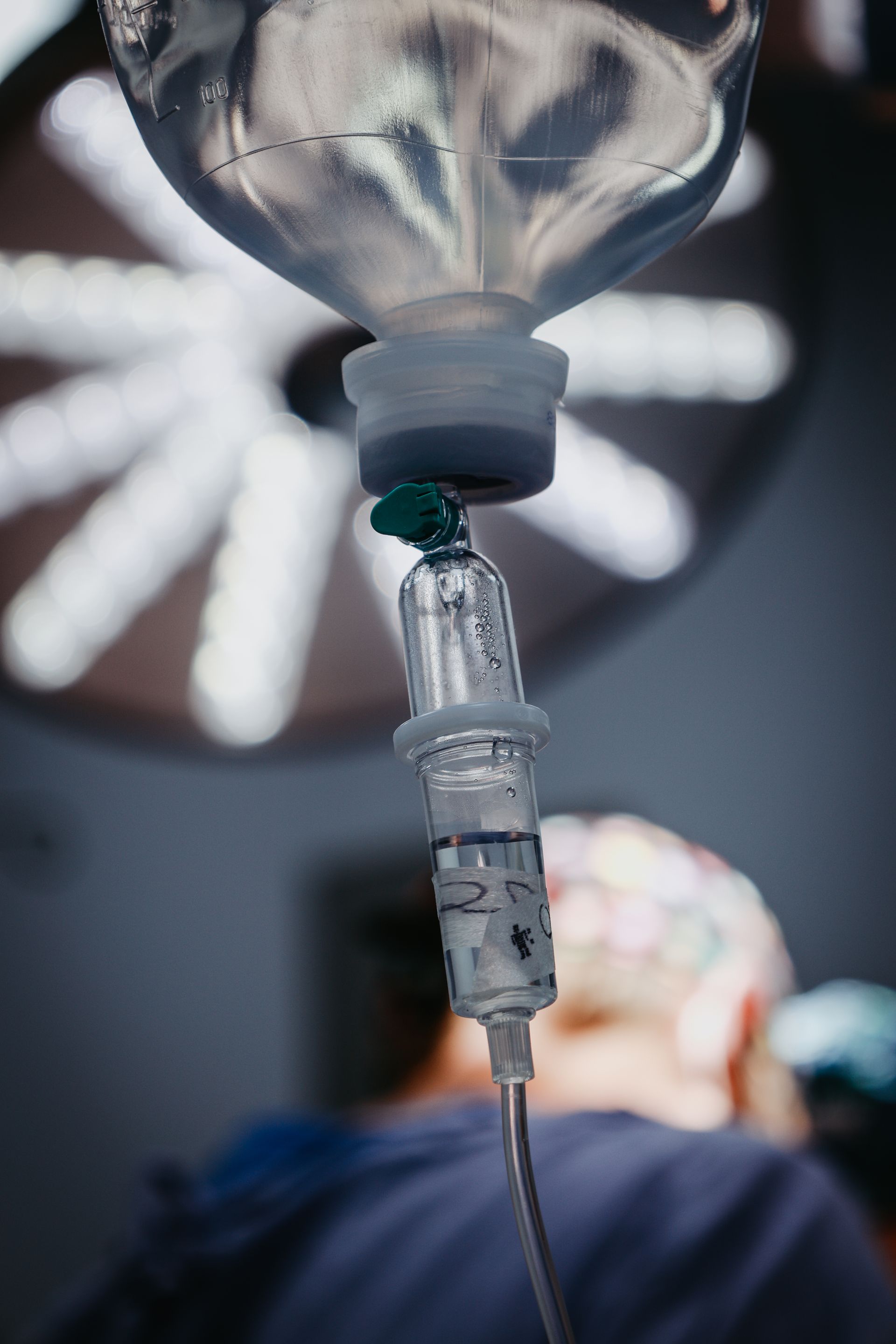 Goteo intravenoso suspendido sobre un paciente en un quirófano de hospital