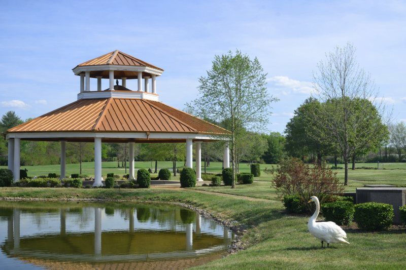 Mount Pleasant, TN cemeteries pavilion by pond with copper roof, manicured lawns, trees and a swan.