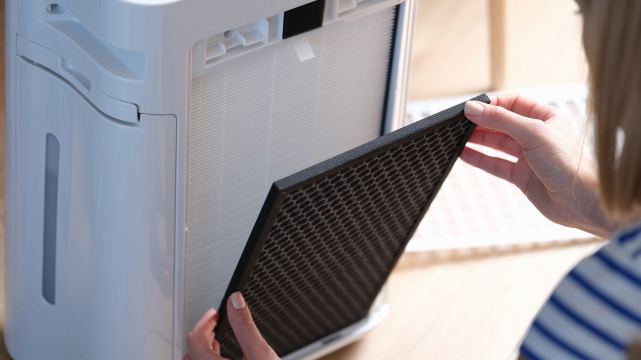 Technician replacing air filter for indoor air quality improvement in HVAC system