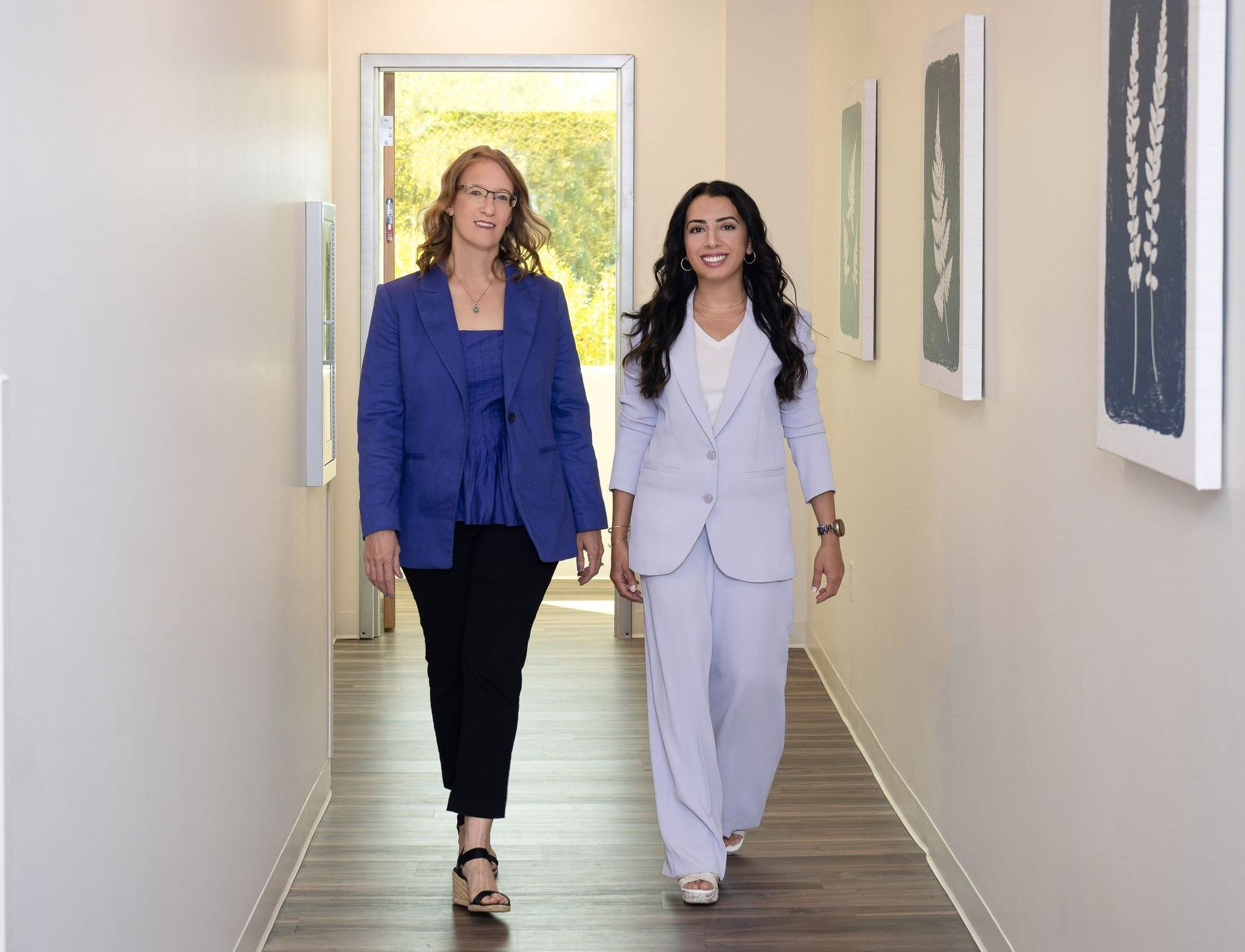 Anjabeen and Arien walk down the hall.