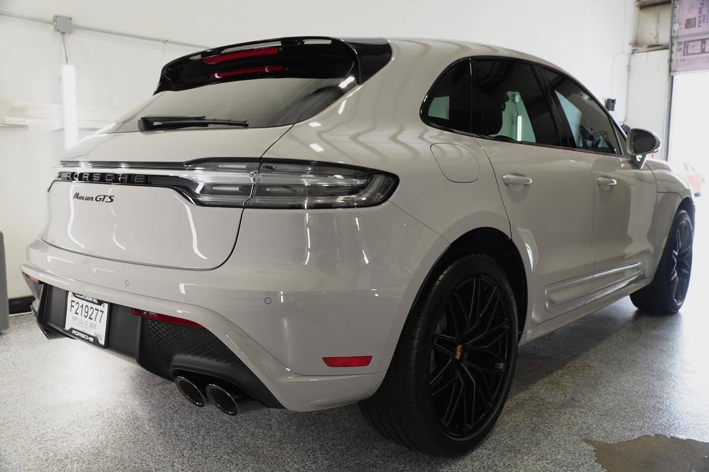 Rear view of a silver SUV with black rims parked inside a garage