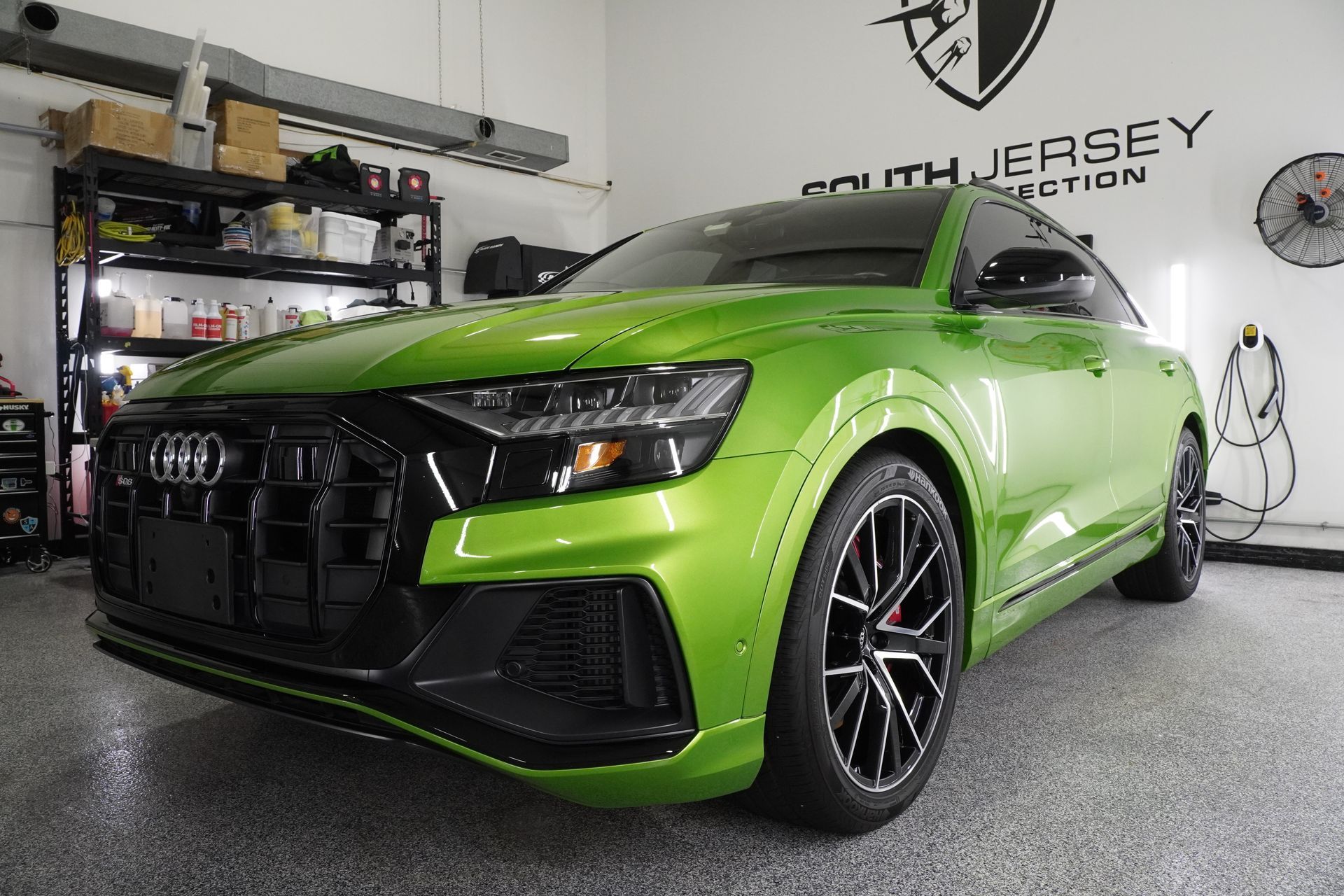 A green audi q8 is parked in a garage.