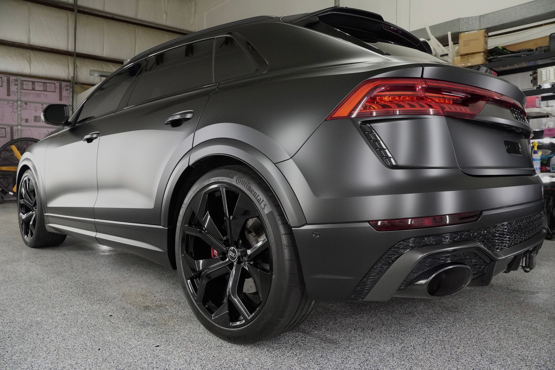 A black audi q8 is parked in a garage.