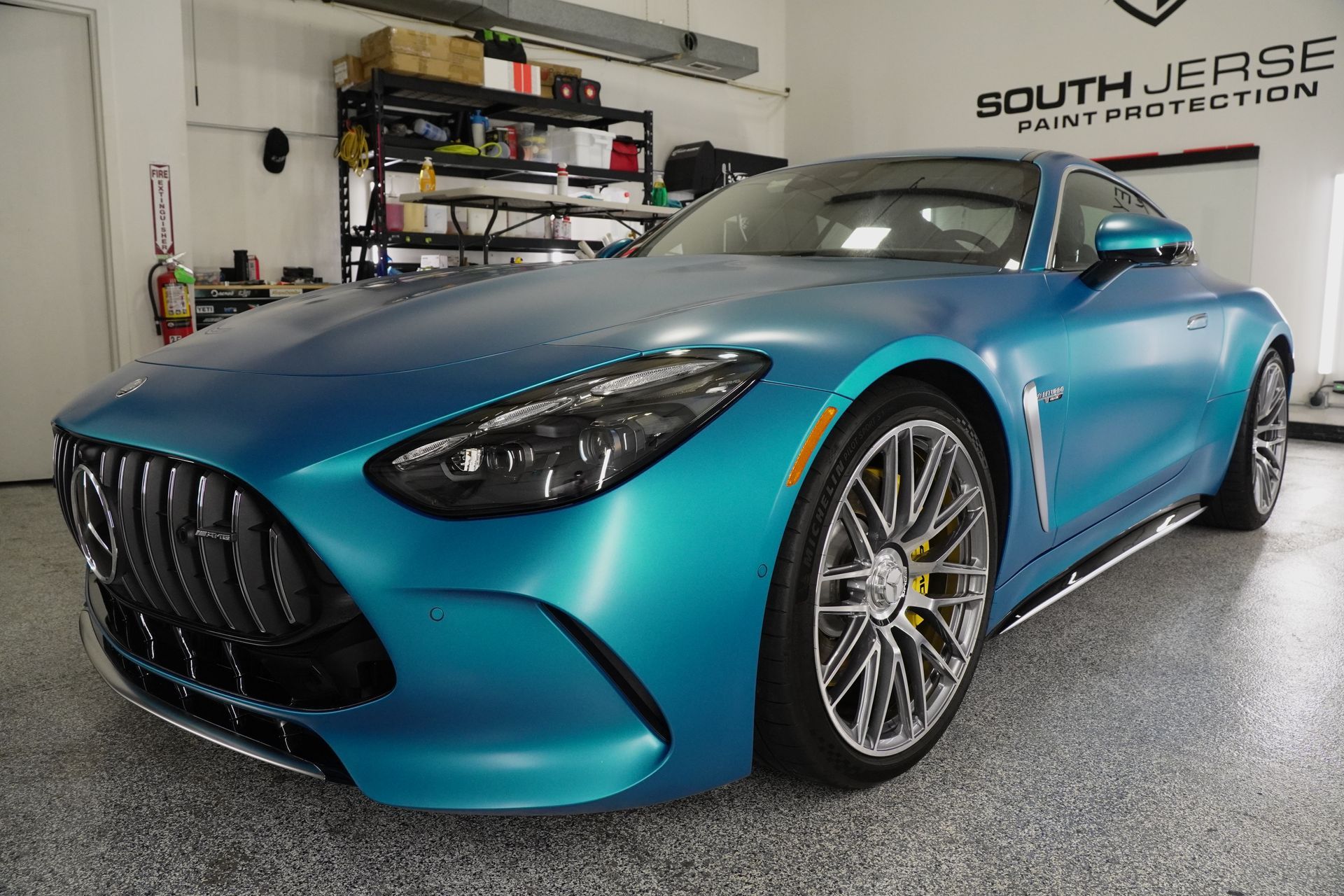 A blue sports car is parked in a garage.