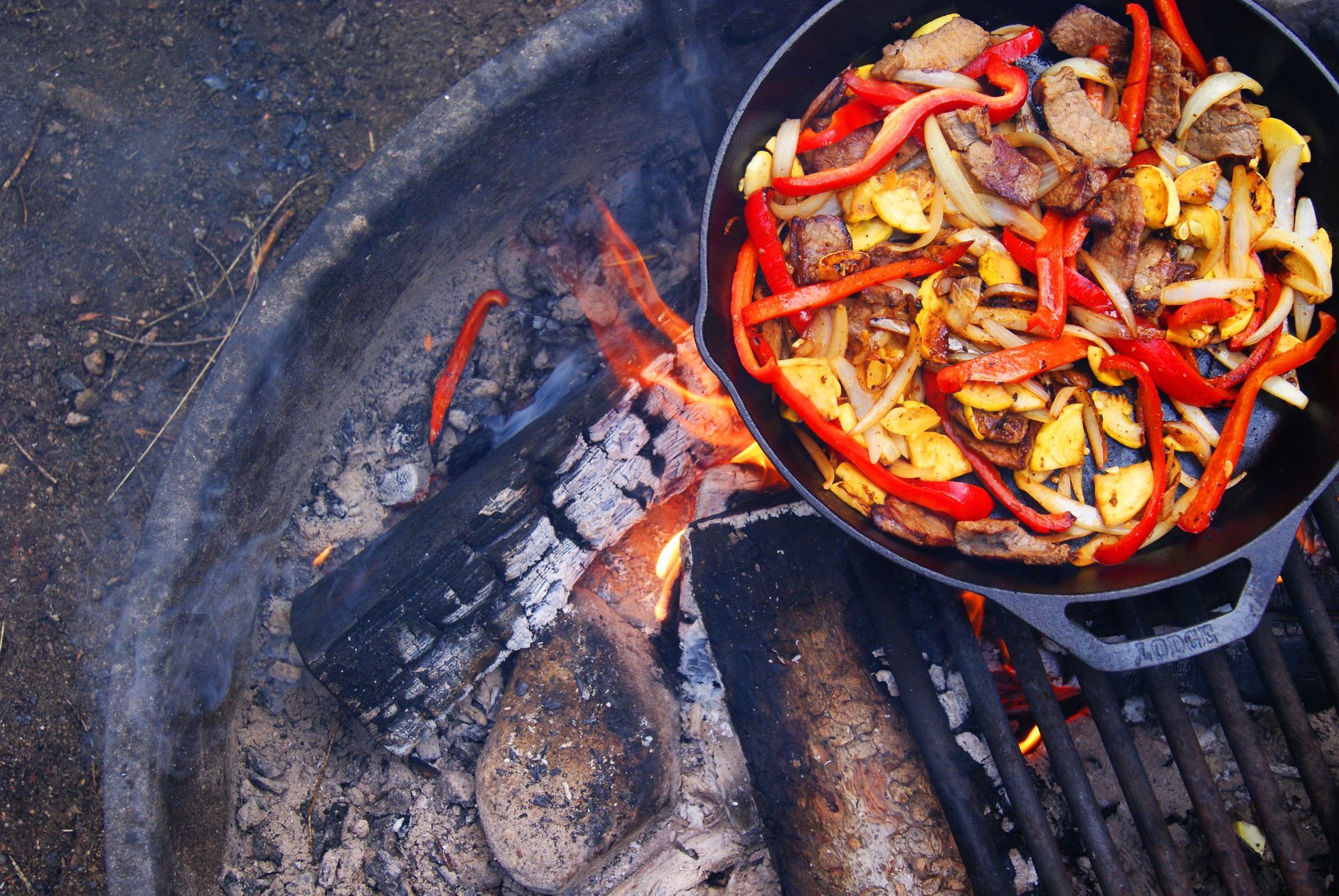 A pan of food is cooking on a grill over a fire