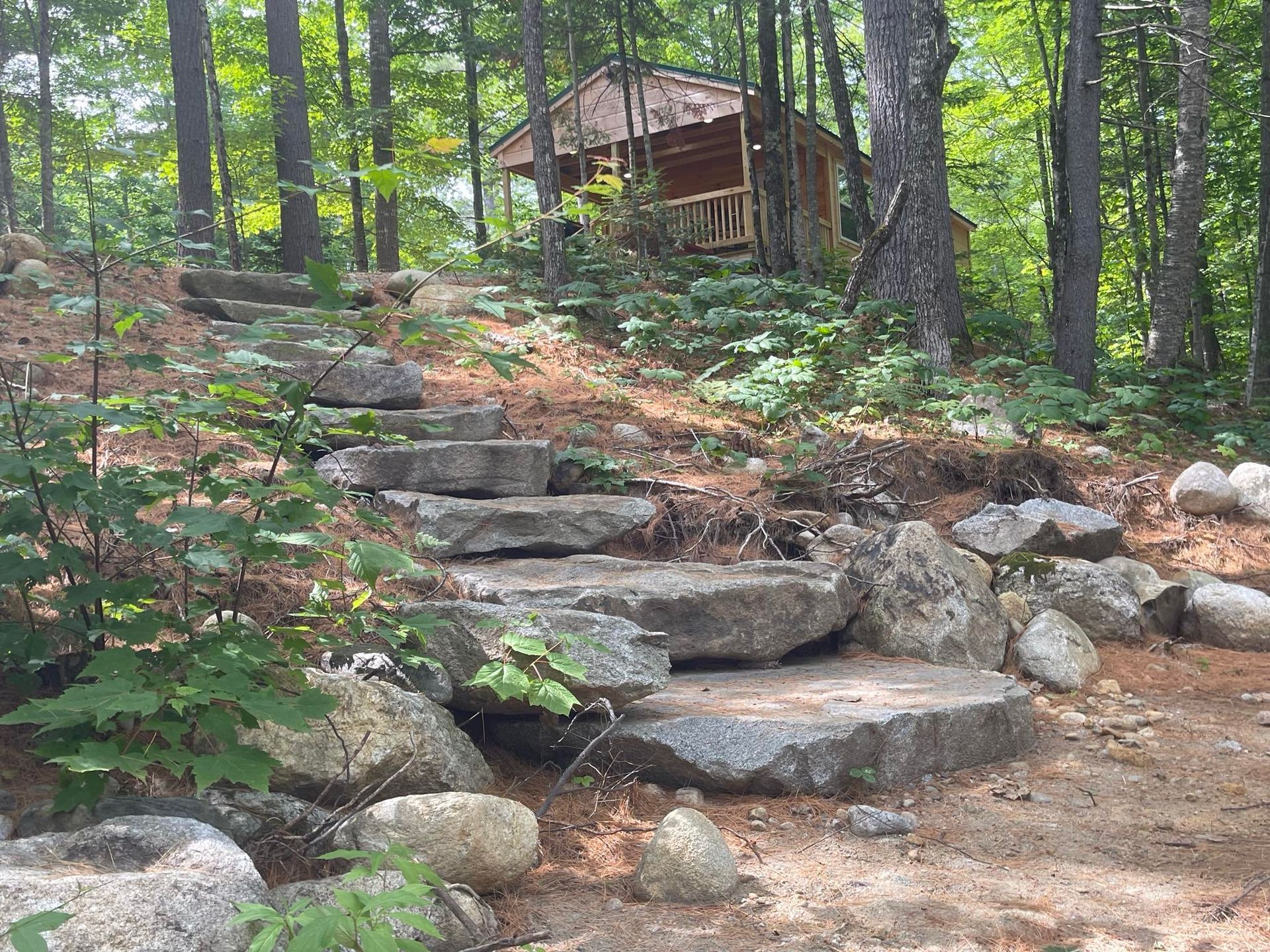 A cabin in the woods with stairs leading up to it