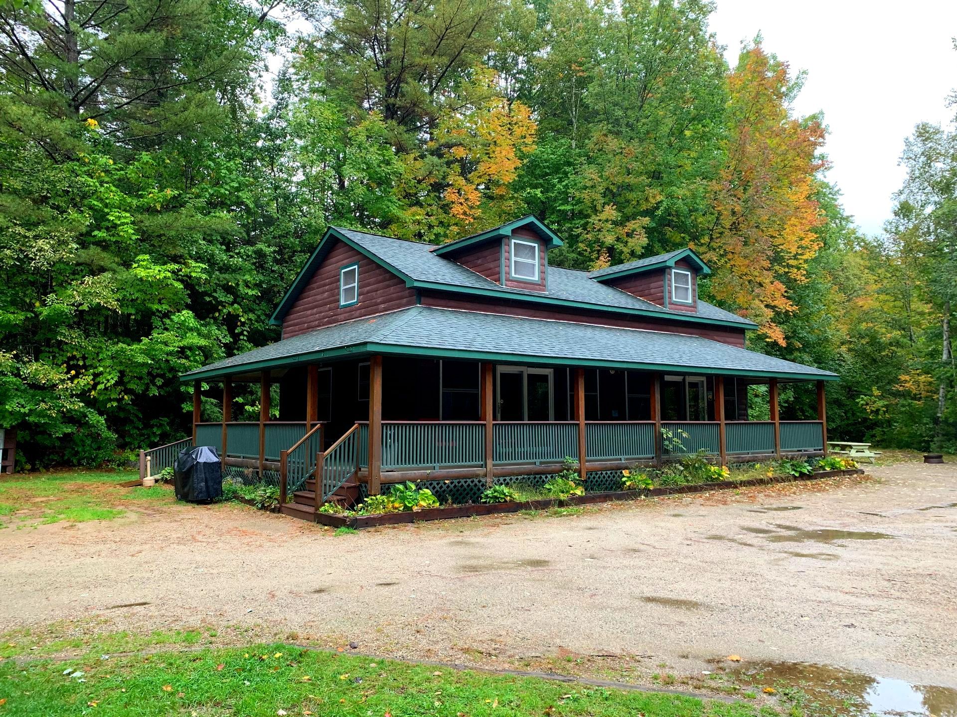 A brick house with a green roof and a porch