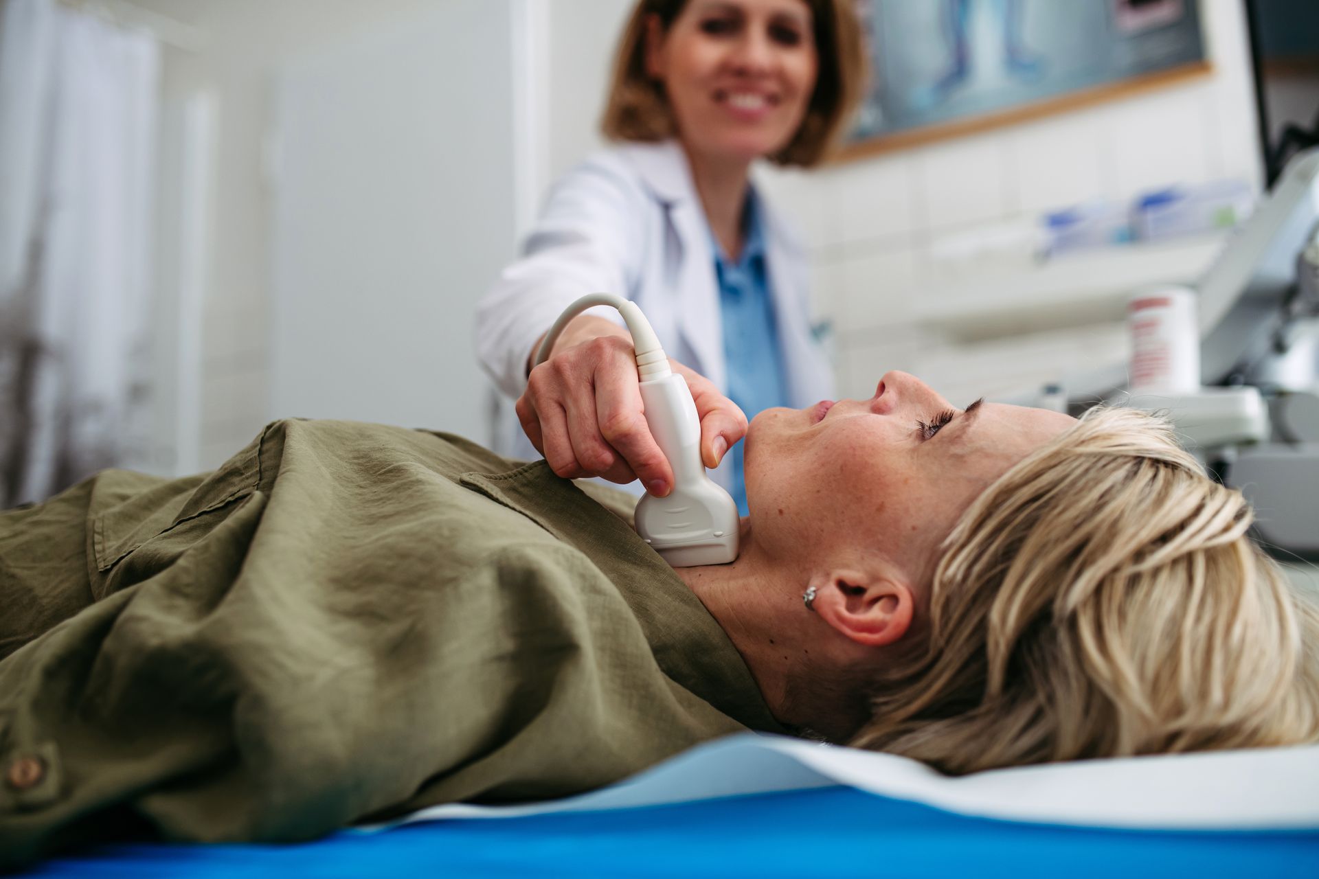 Doctor using ultrasound probe on patient lying on examination table