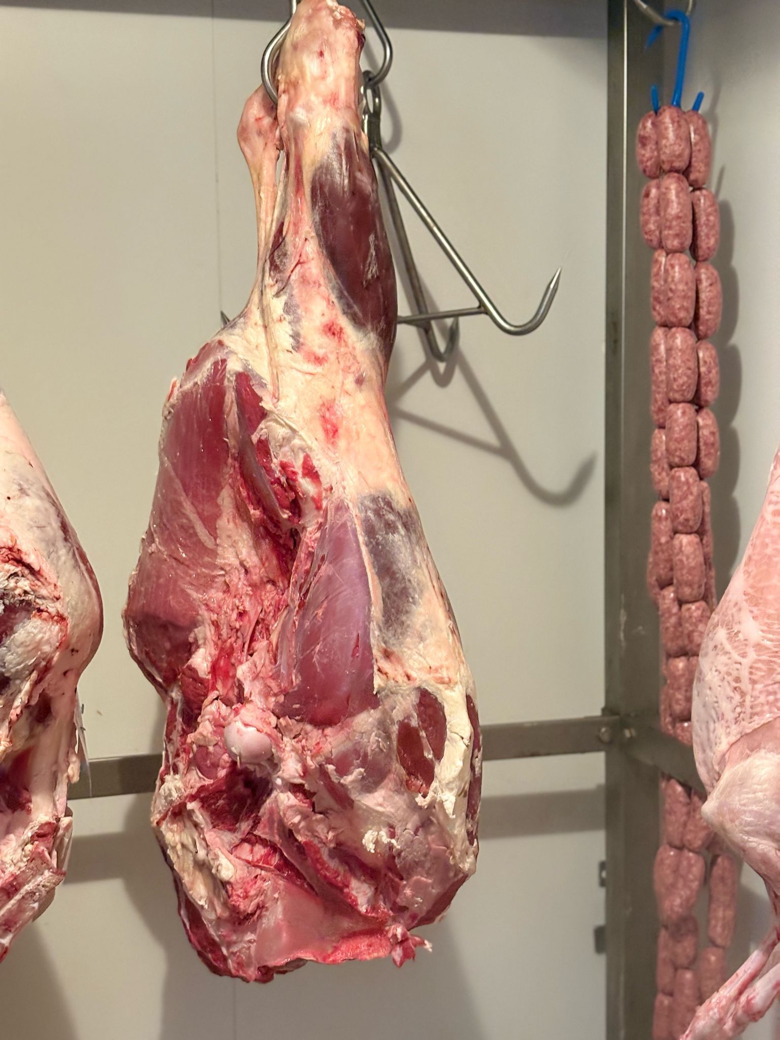 Un grosso pezzo di carne è appeso a un gancio