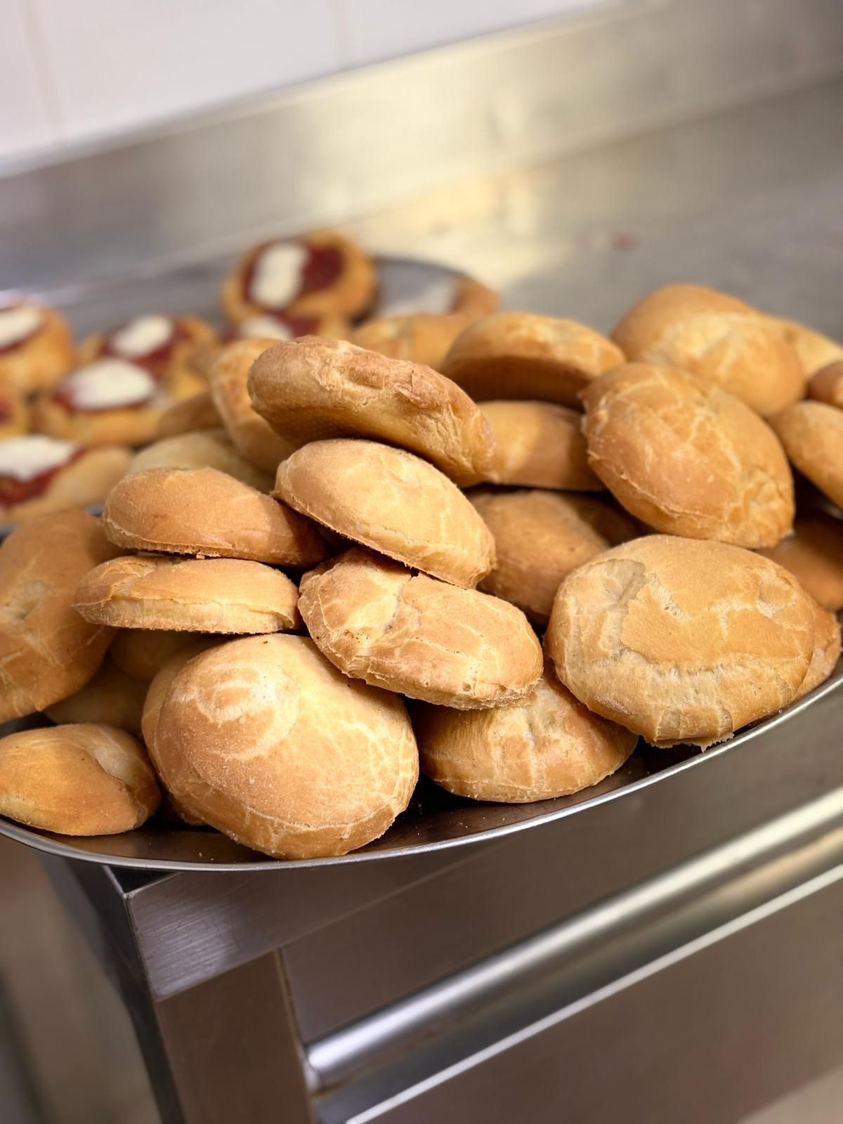Un piatto di pane è appoggiato su un bancone in acciaio inossidabile.