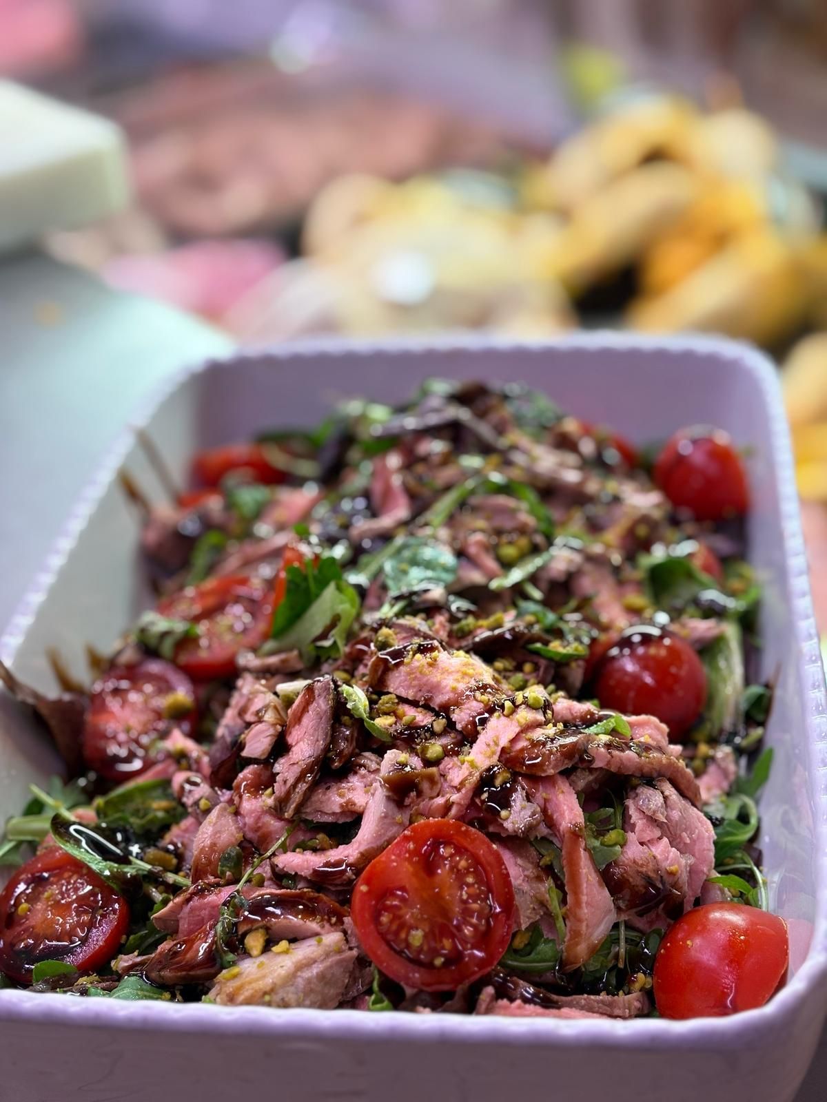 Una casseruola piena di carne, pomodori e altre verdure.