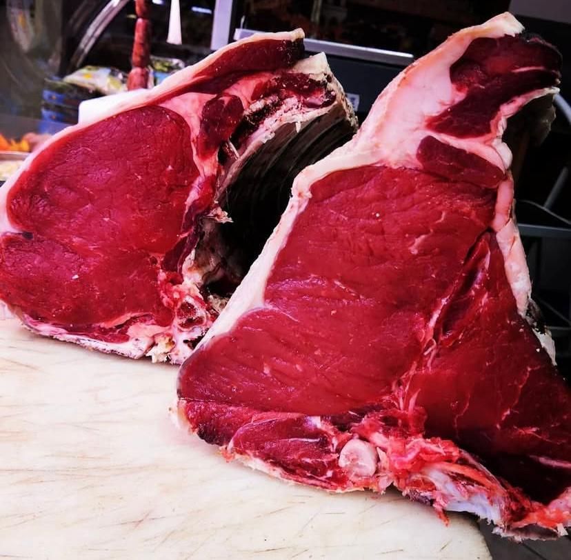Due grandi pezzi di carne sono appoggiati su un tagliere