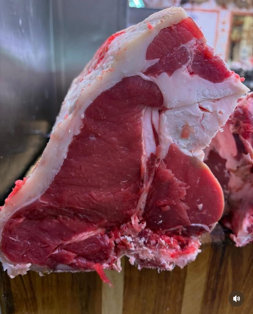 Un pezzo di manzo crudo è appoggiato su un tavolo di legno.