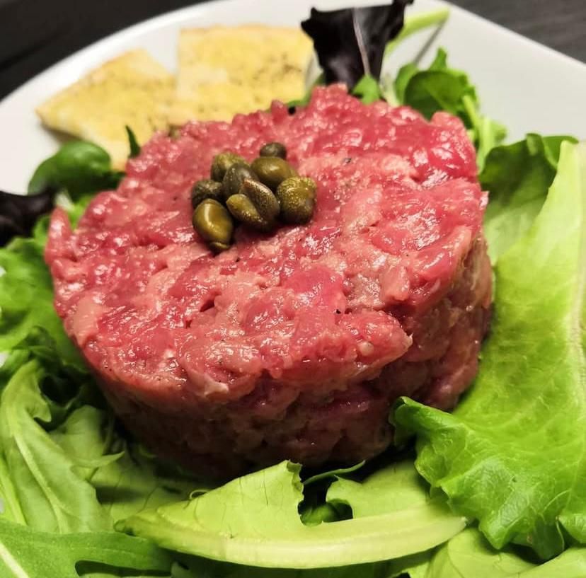 Un primo piano di un piatto di cibo con carne e lattuga