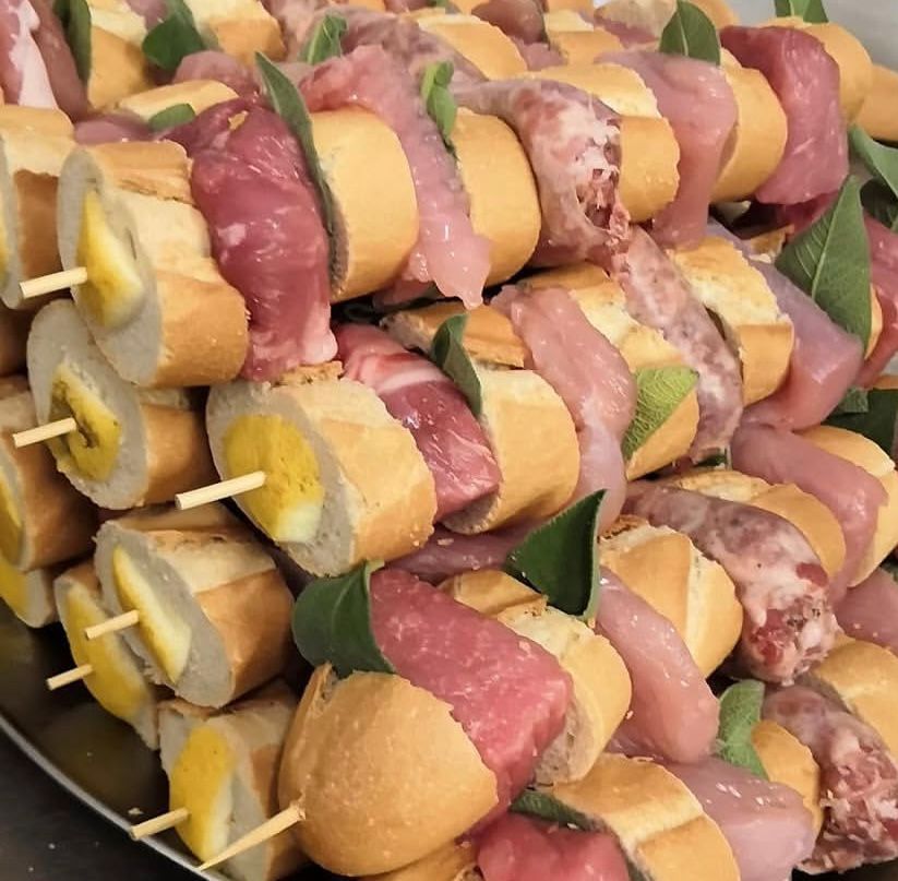 Un mazzo di spiedini con carne e banane sopra