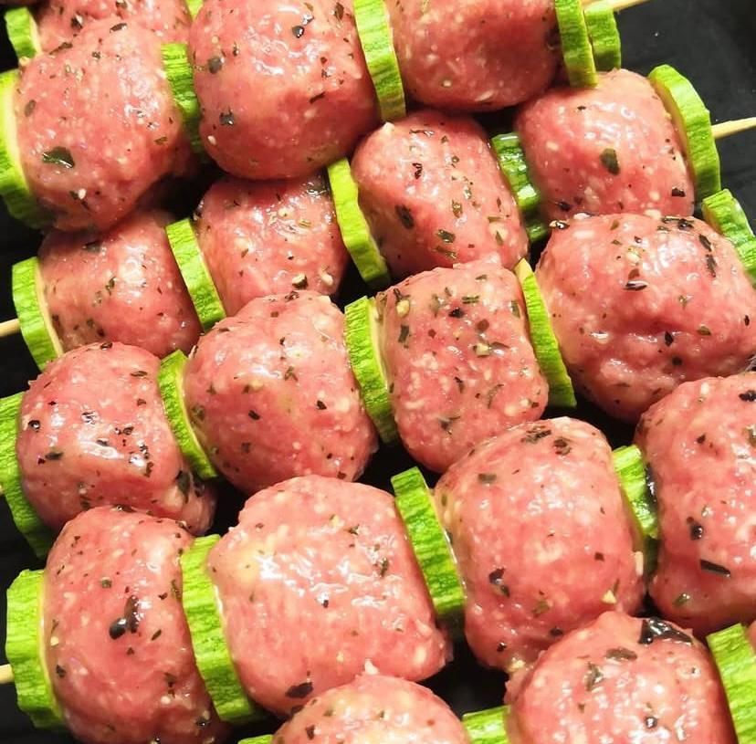 Un mazzo di polpette infilzate su spiedini con fette di cetriolo