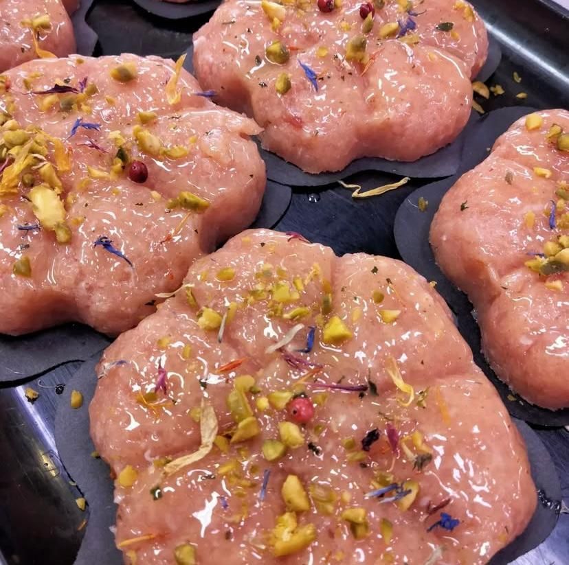Un primo piano di un vassoio di cibo con fiori e pistacchi