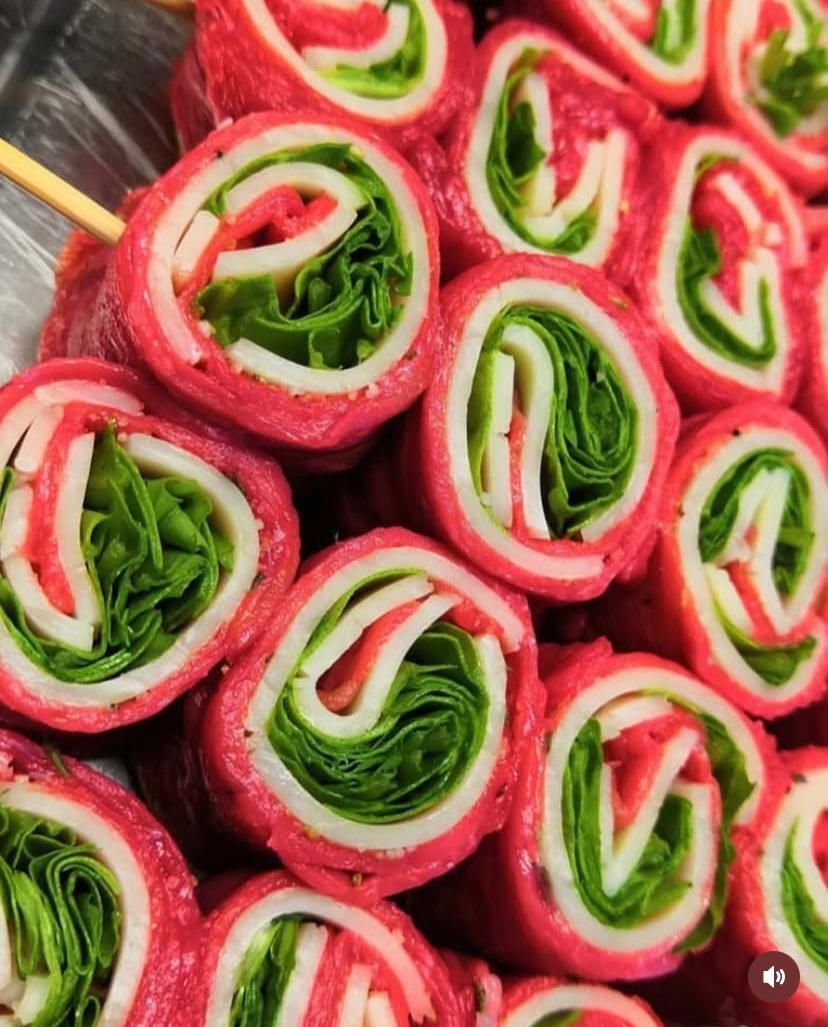 Un mazzo di involtini di carne e lattuga su bastoncini
