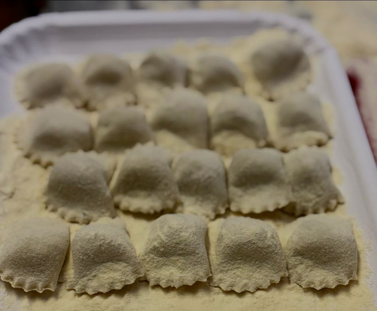 Un vassoio di ravioli è appoggiato su un tavolo.