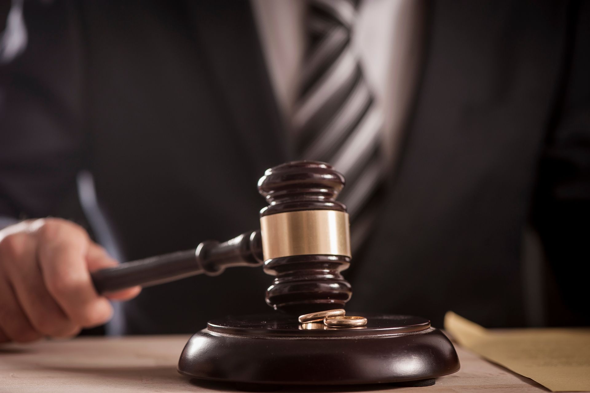 Wedding rings resting on a judge's gavel base, while the solicitor holds the gavel over them. Wedding rings resting on a judge's gavel base, while the solicitor holds the gavel over them.