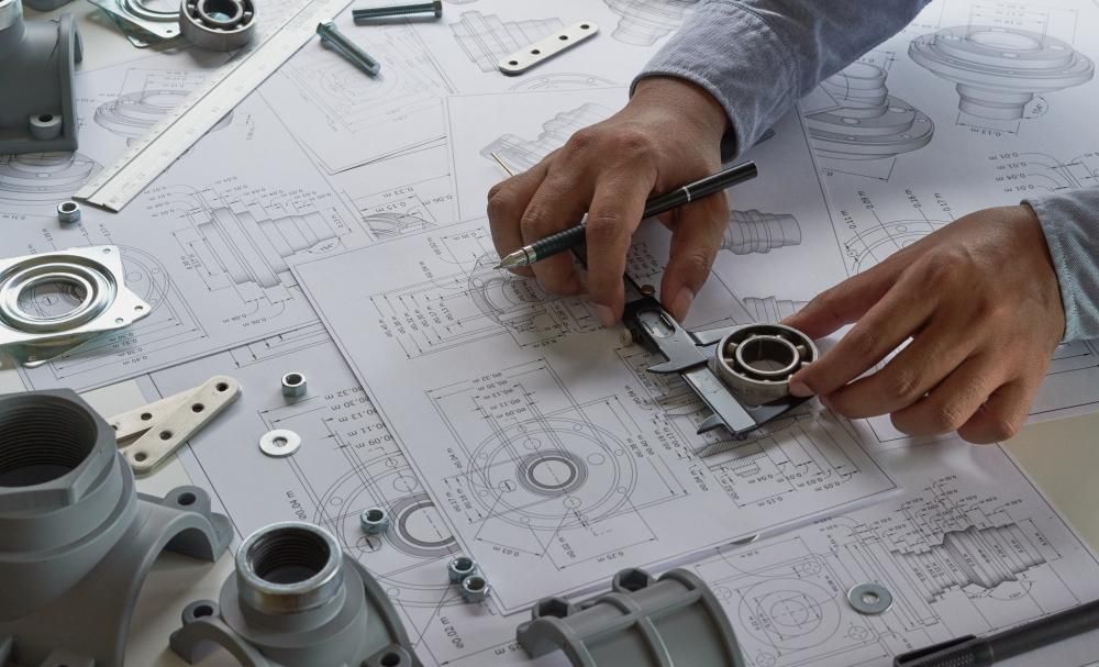 A Person is Using a Caliper to Measure a Bearing on a Drawing — Ballina Bearing Supplies In Ballina, NSW