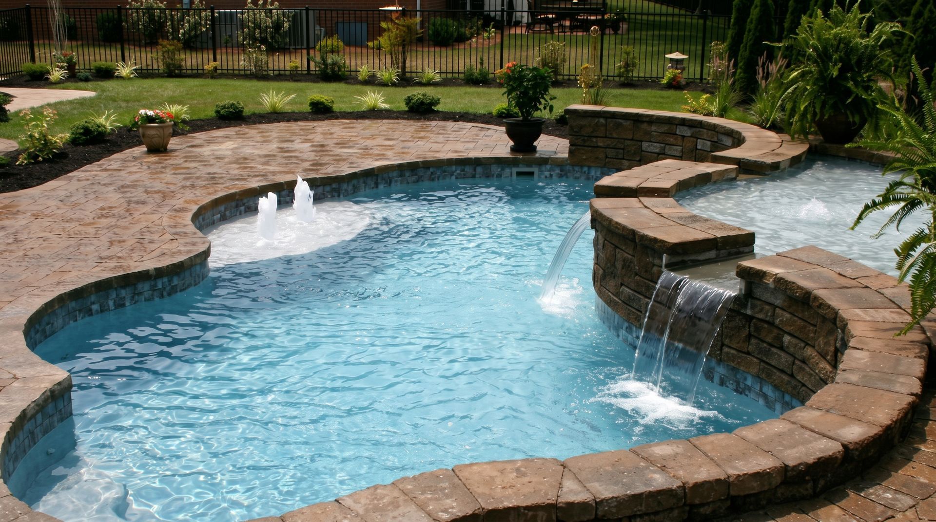 Kidney-shaped backyard swimming pool with blue water, brick coping, and a small waterfall feature