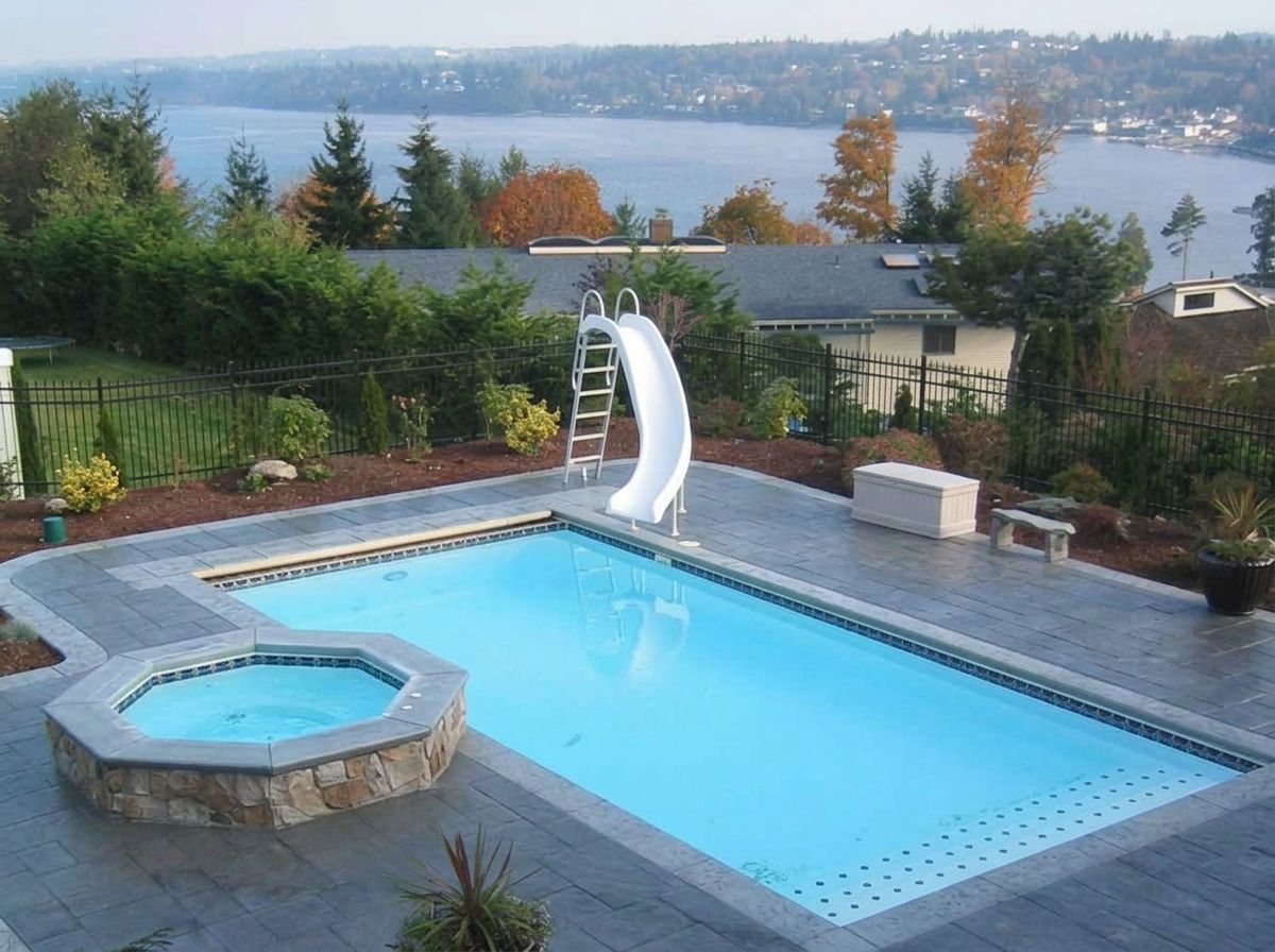 Backyard pool with water slide, hot tub, and lake view in the background