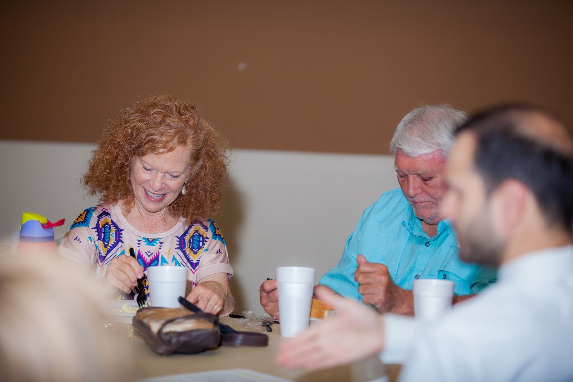 A group of people are sitting at a table drinking coffee.