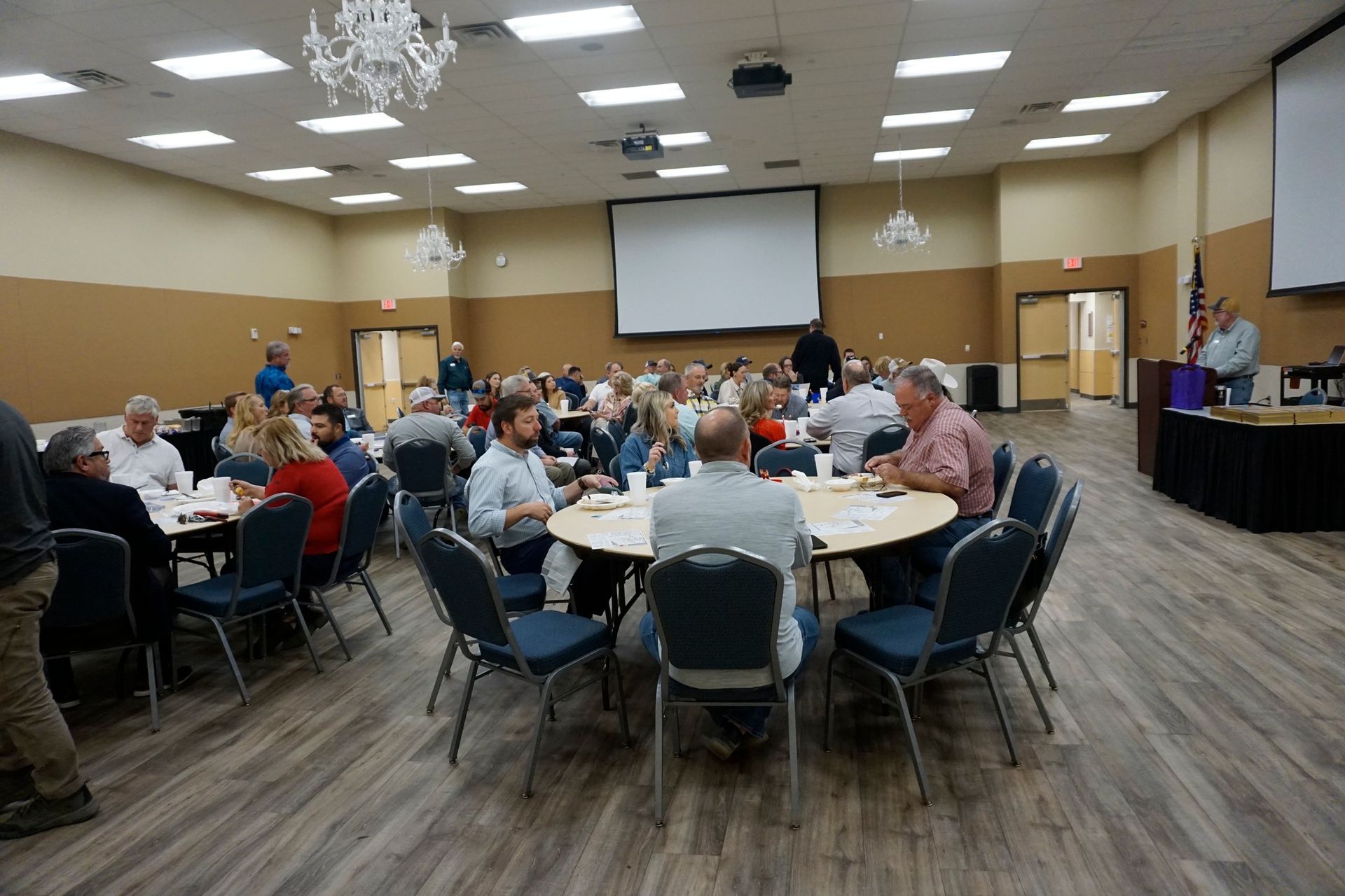 Banquet hall with people seated at round tables for a community gathering or meal