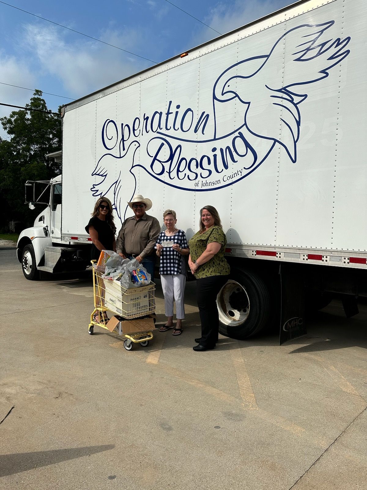 A group of people standing in front of a truck that says operation blessing.