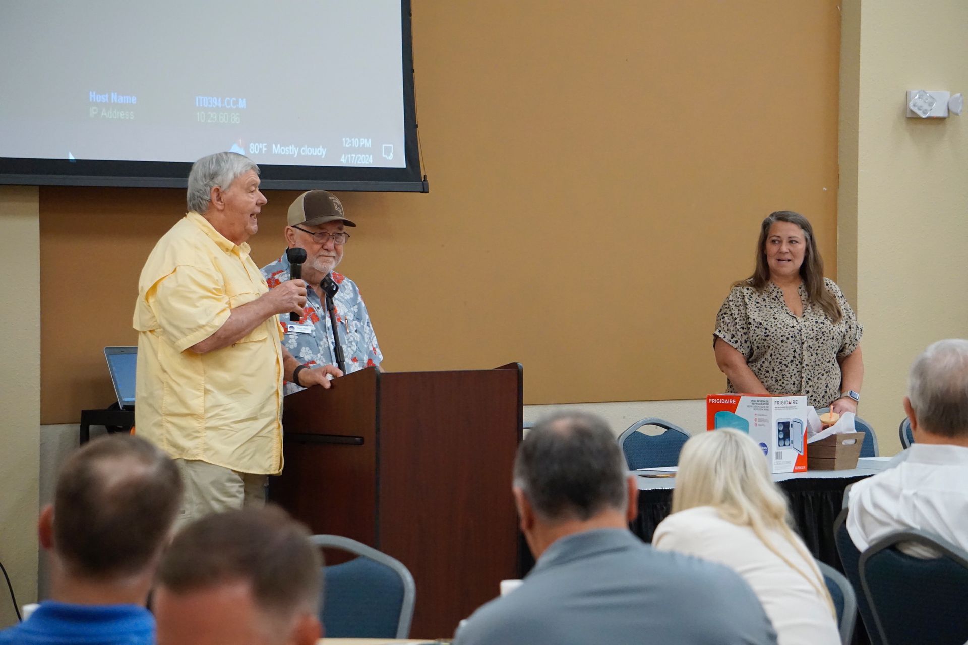 A man is standing at a podium giving a presentation to a group of people.