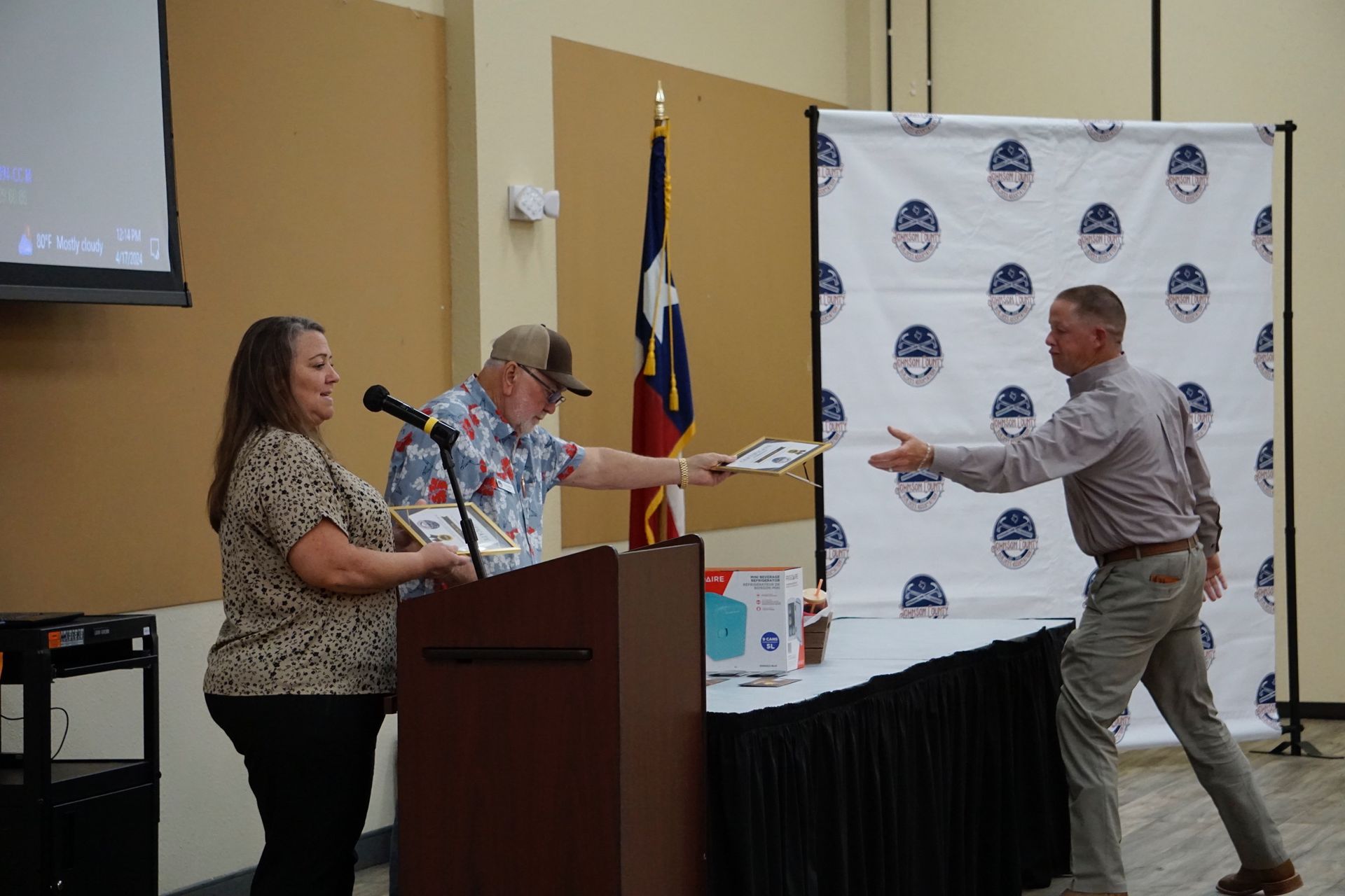 A man is giving a certificate to a woman at a podium.