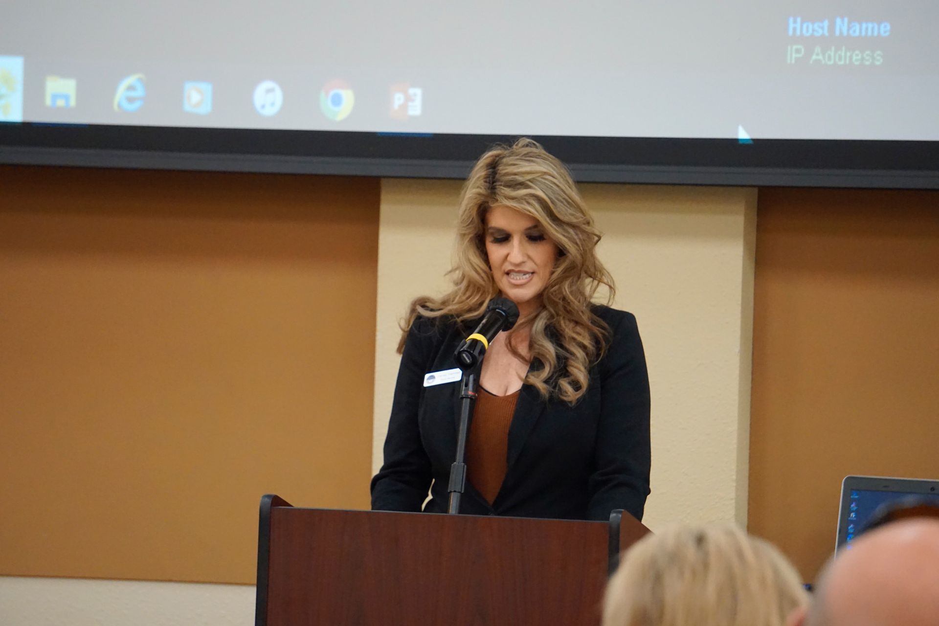 A woman is standing at a podium speaking into a microphone.