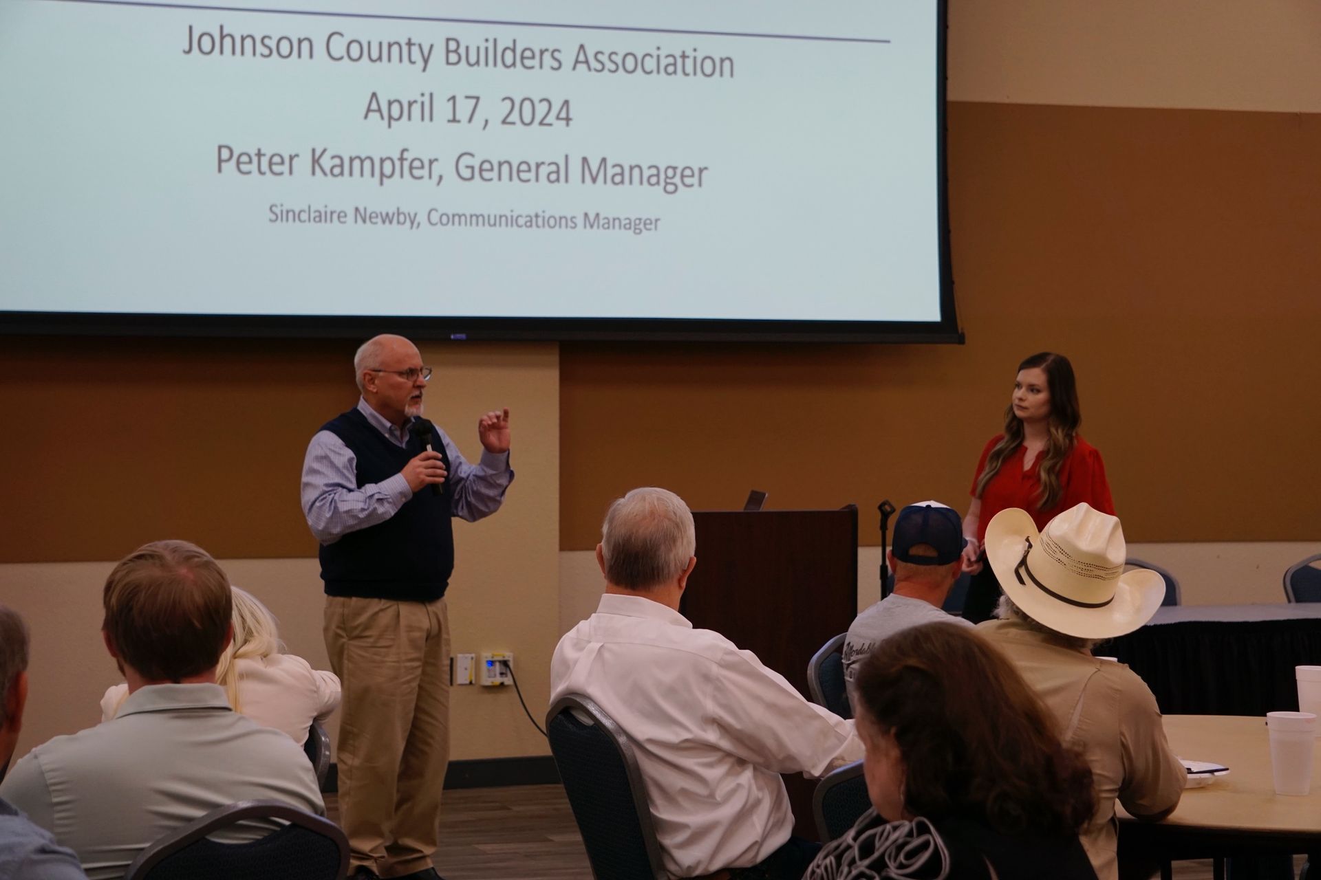 A man and a woman are giving a presentation to a group of people.
