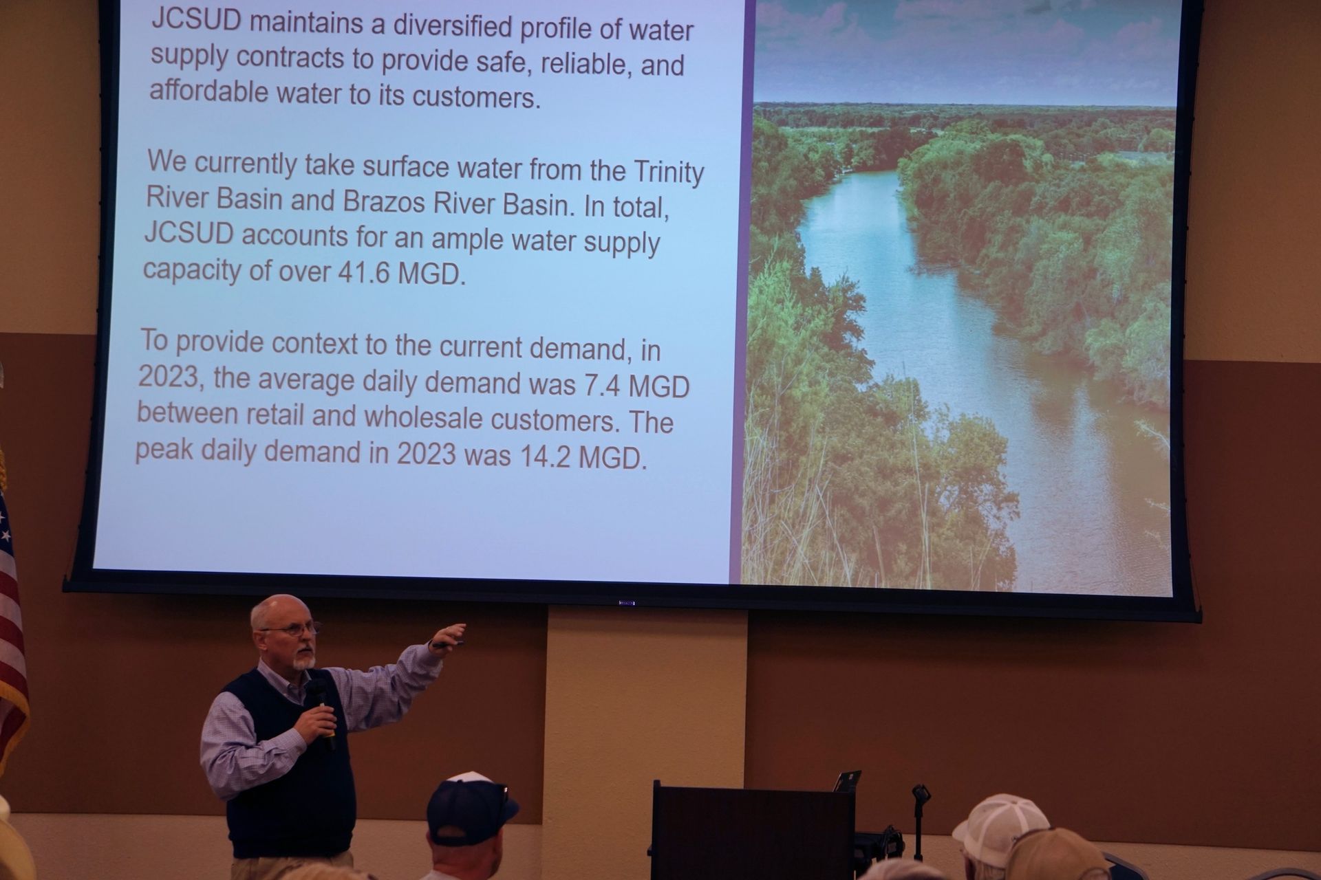 A man is giving a presentation in front of a large screen