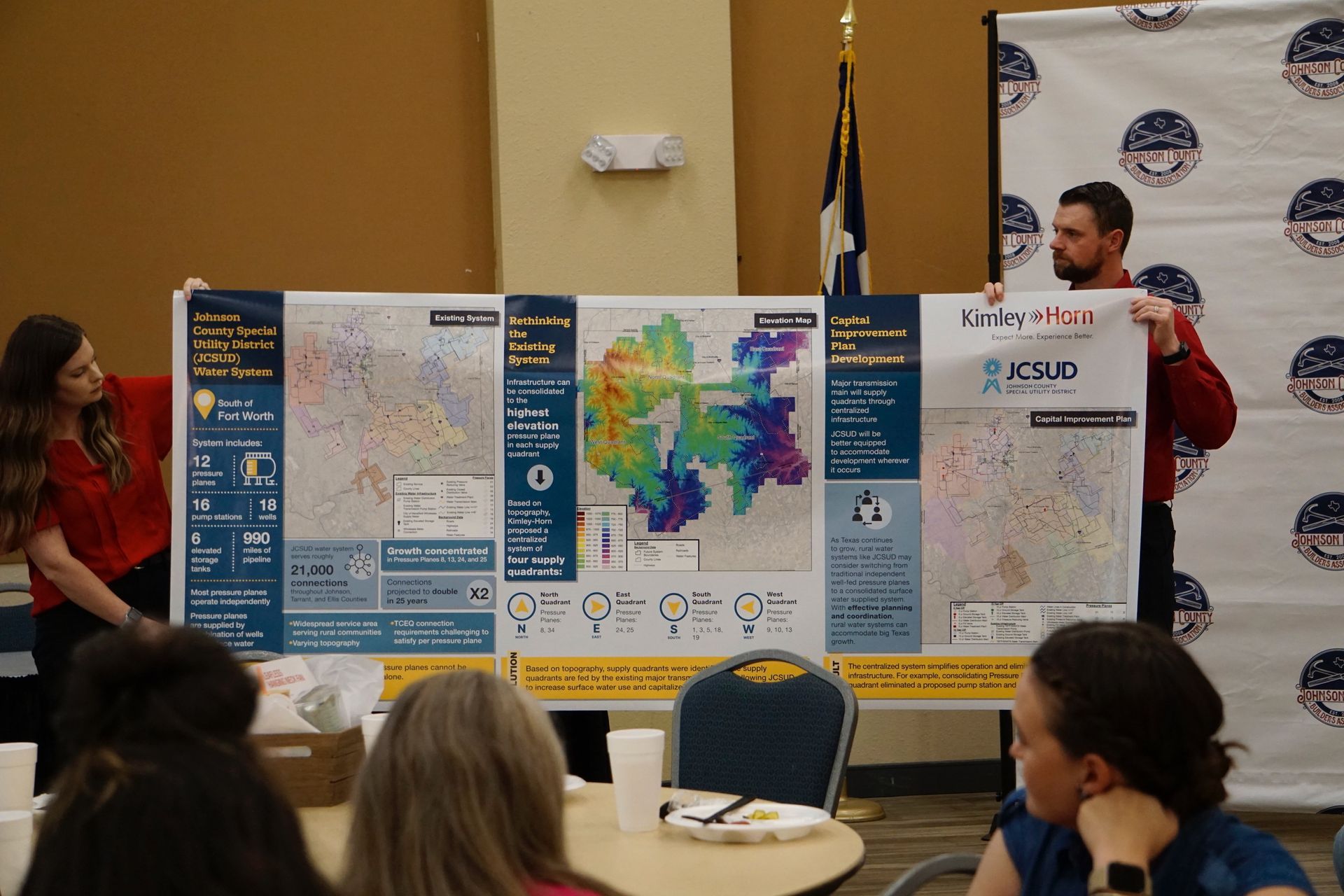 A group of people are sitting around a table looking at a map.