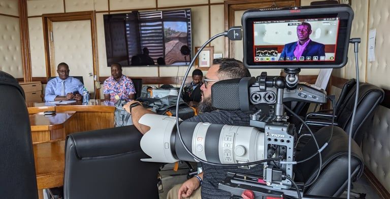 TV camera filming a panel discussion in an office meeting room